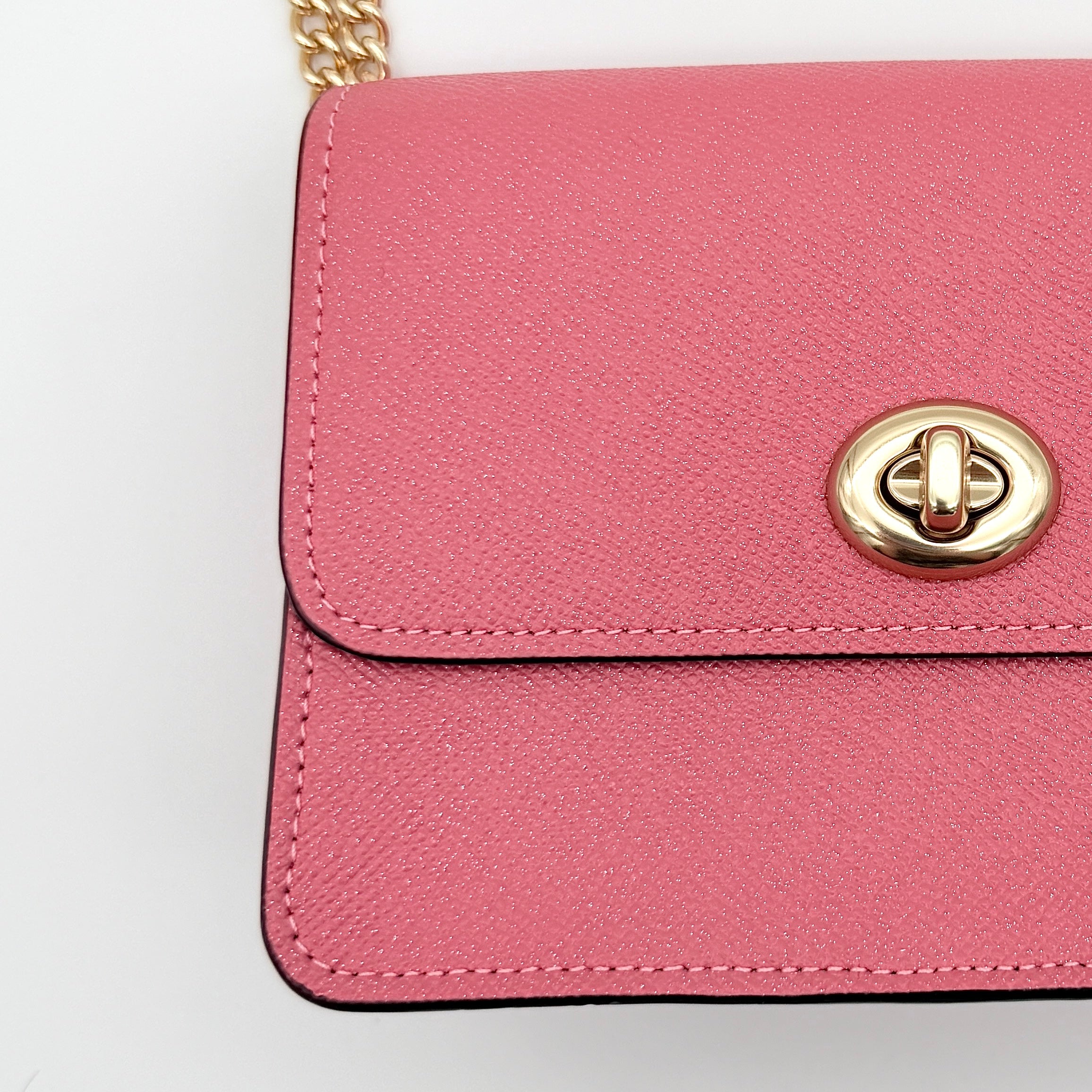 Coach Bowery Turnlock shoulder bag in pink saffiano leather with a gold-tone chain strap and signature Coach hangtag.