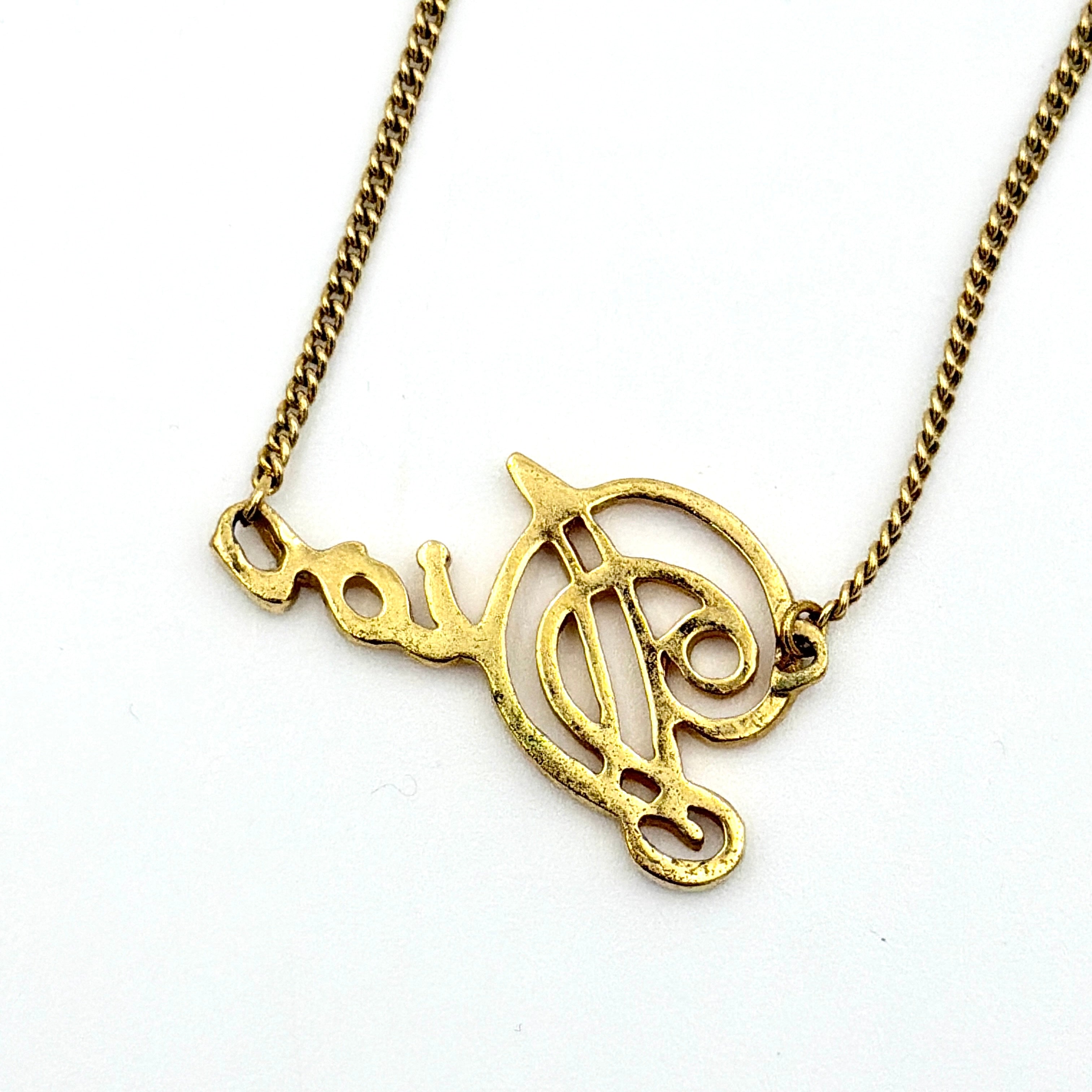 Dior gold logo letter necklace featuring an elegant script pendant on a fine gold chain.