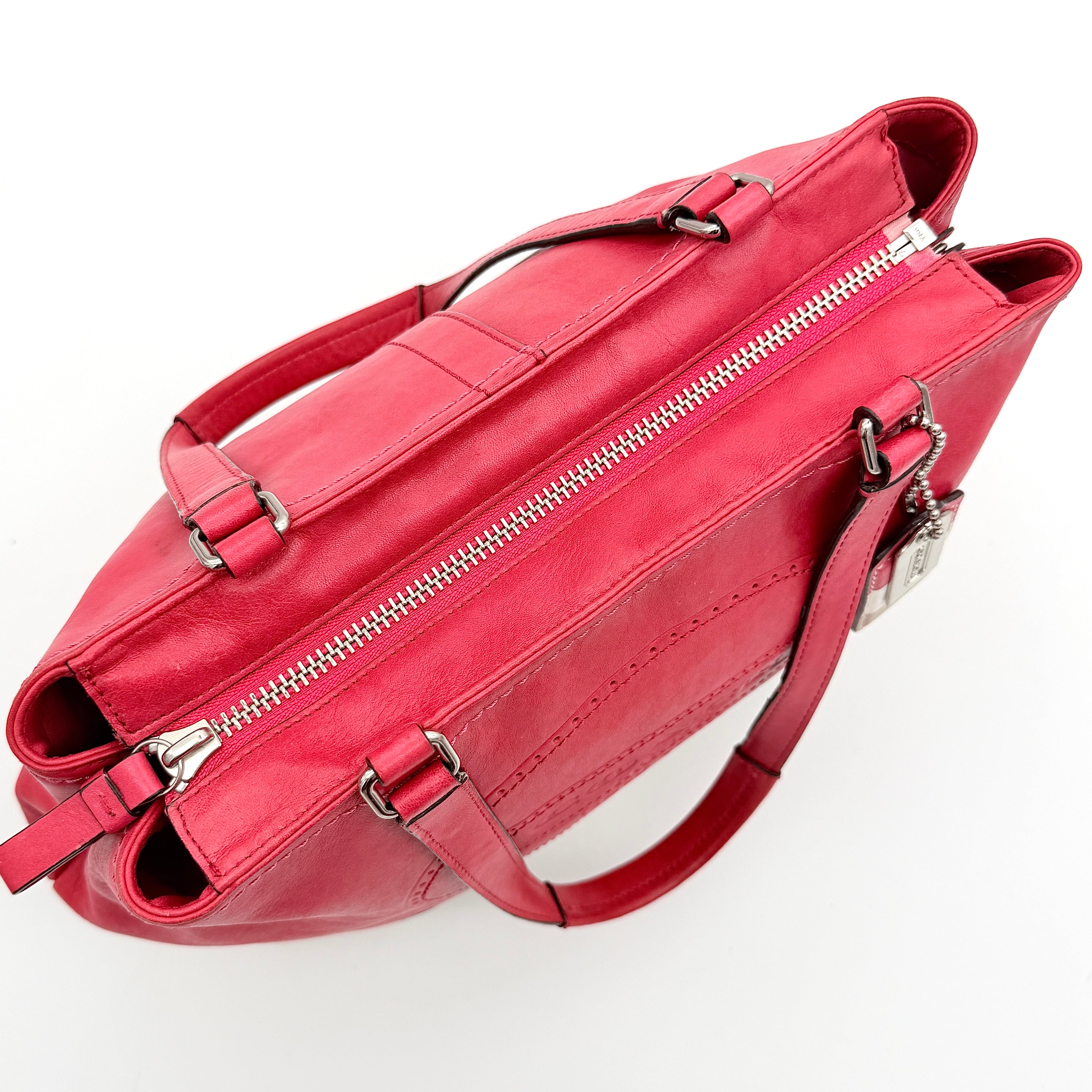 Coach Hamptons Weekend Perforated Tote in red and cream leather with dual top handles and silver hardware.