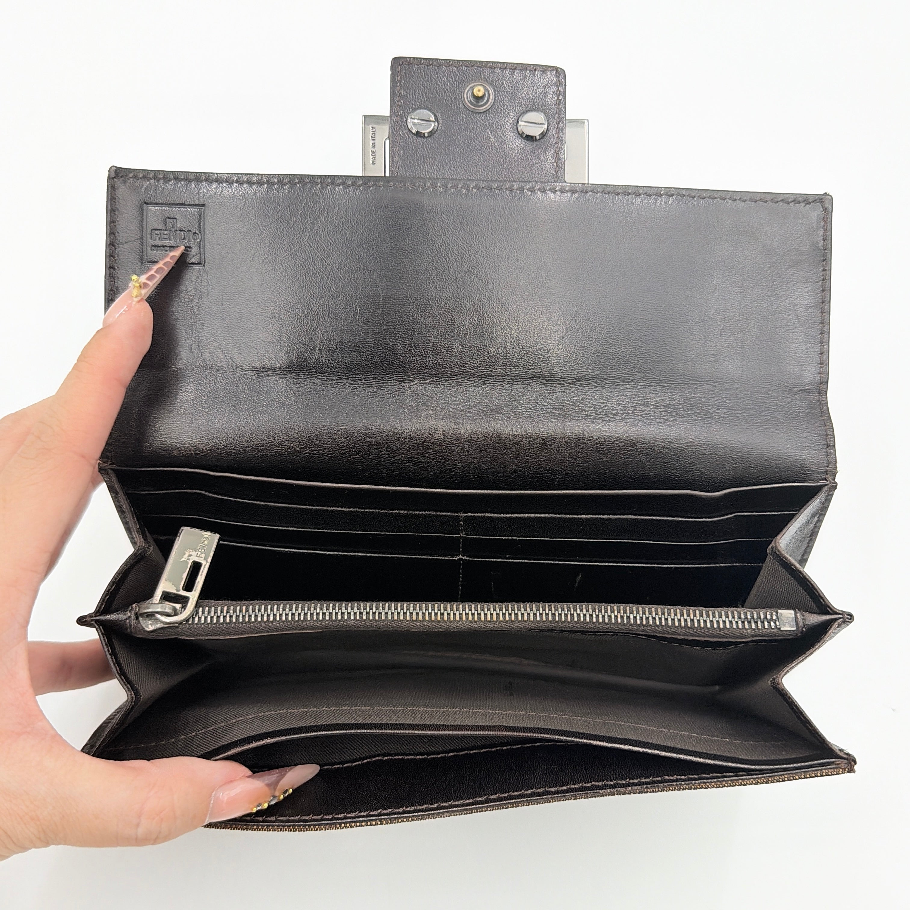 Front view of the Fendi FF Zucca long wallet in brown with signature monogram canvas and silver logo buckle.