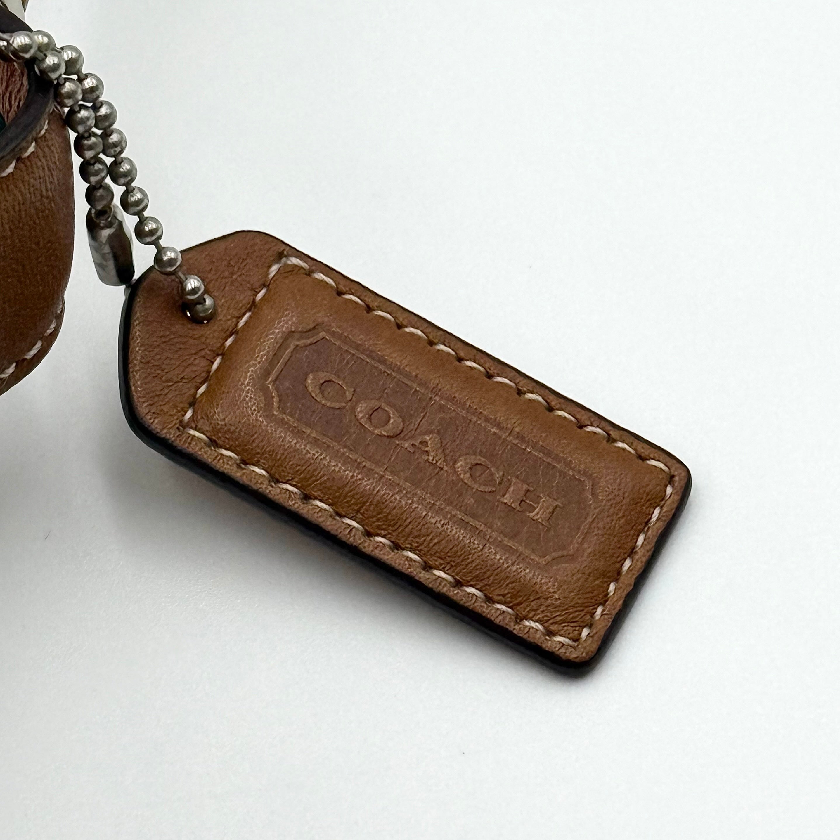Coach signature beige jacquard hobo shoulder bag with tan leather trim and silver-tone hardware.
