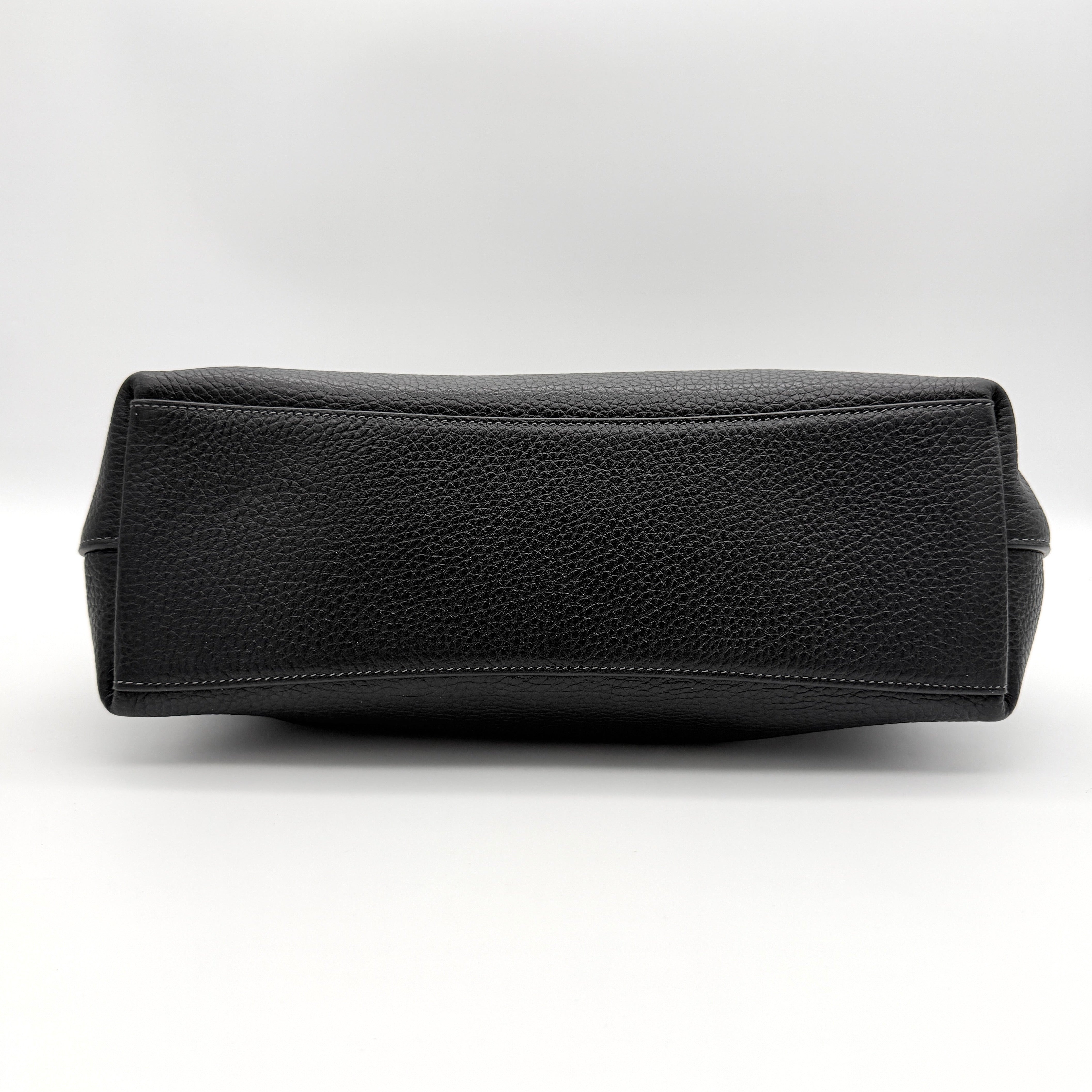 Coach Signature Laurel Shoulder Bag in black pebbled leather with gold hardware and a top zip closure.