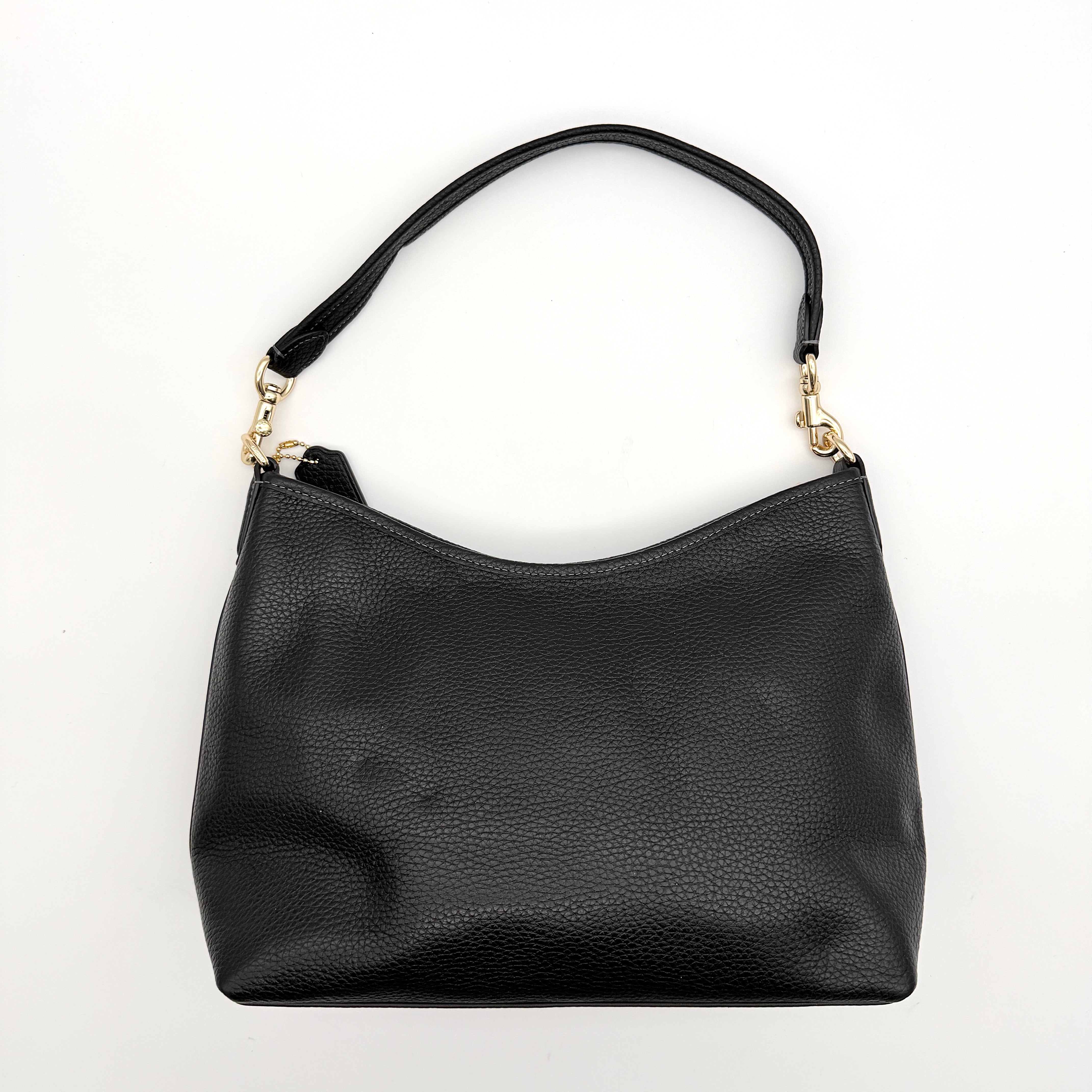 Coach Signature Laurel Shoulder Bag in black pebbled leather with gold hardware and a top zip closure.
