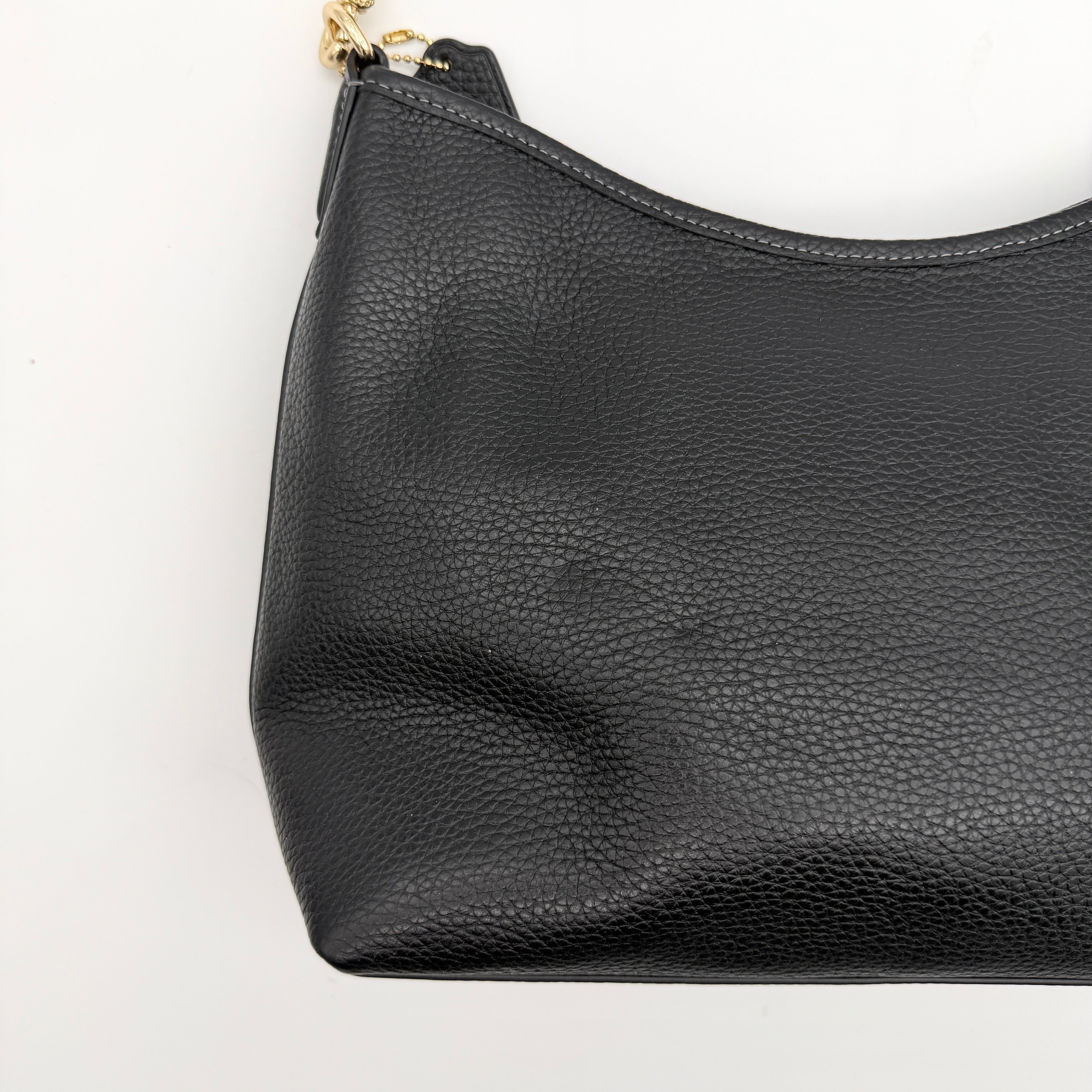 Coach Signature Laurel Shoulder Bag in black pebbled leather with gold hardware and a top zip closure.