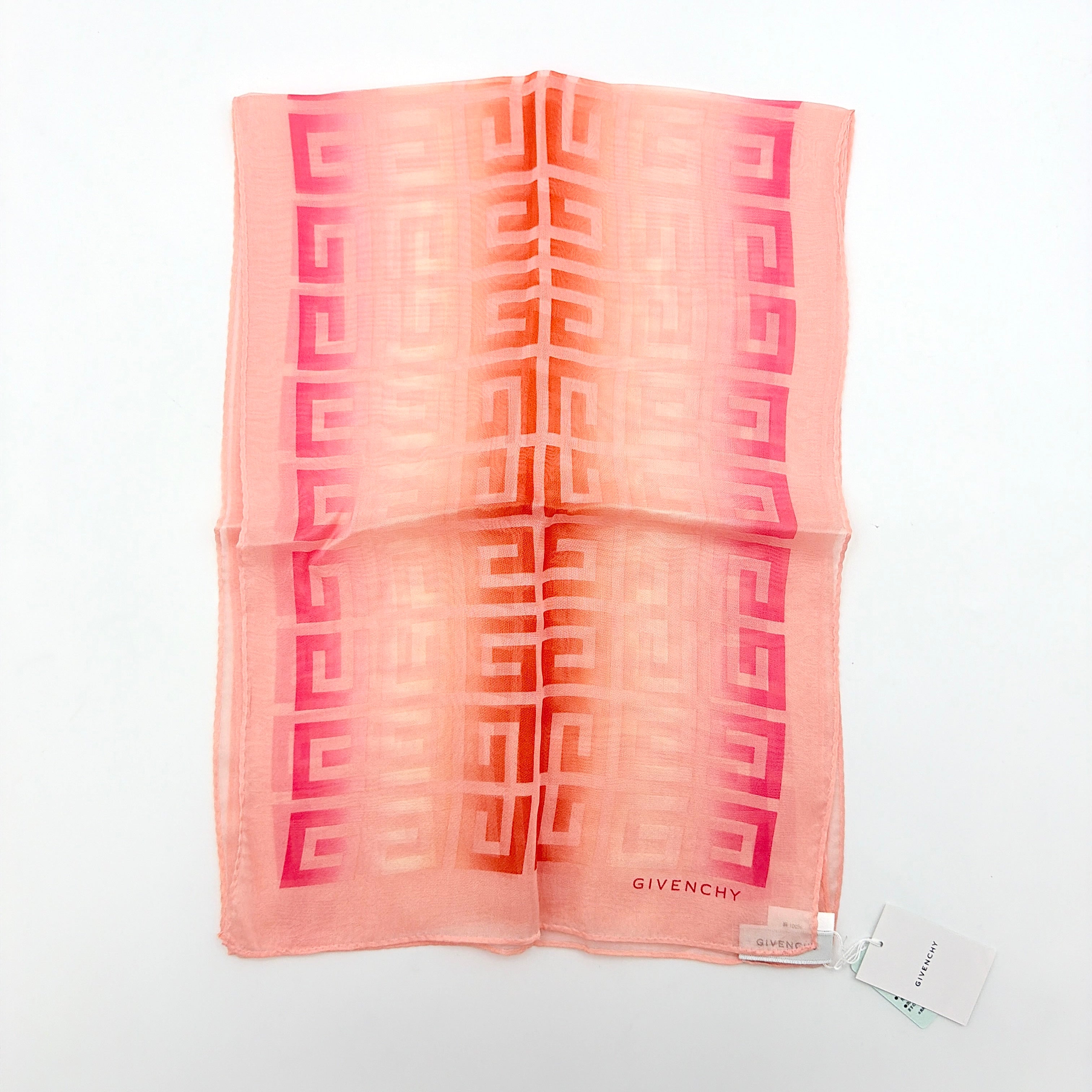 Givenchy silk scarf in pink with orange monogram pattern, showing the full length and original tags attached.