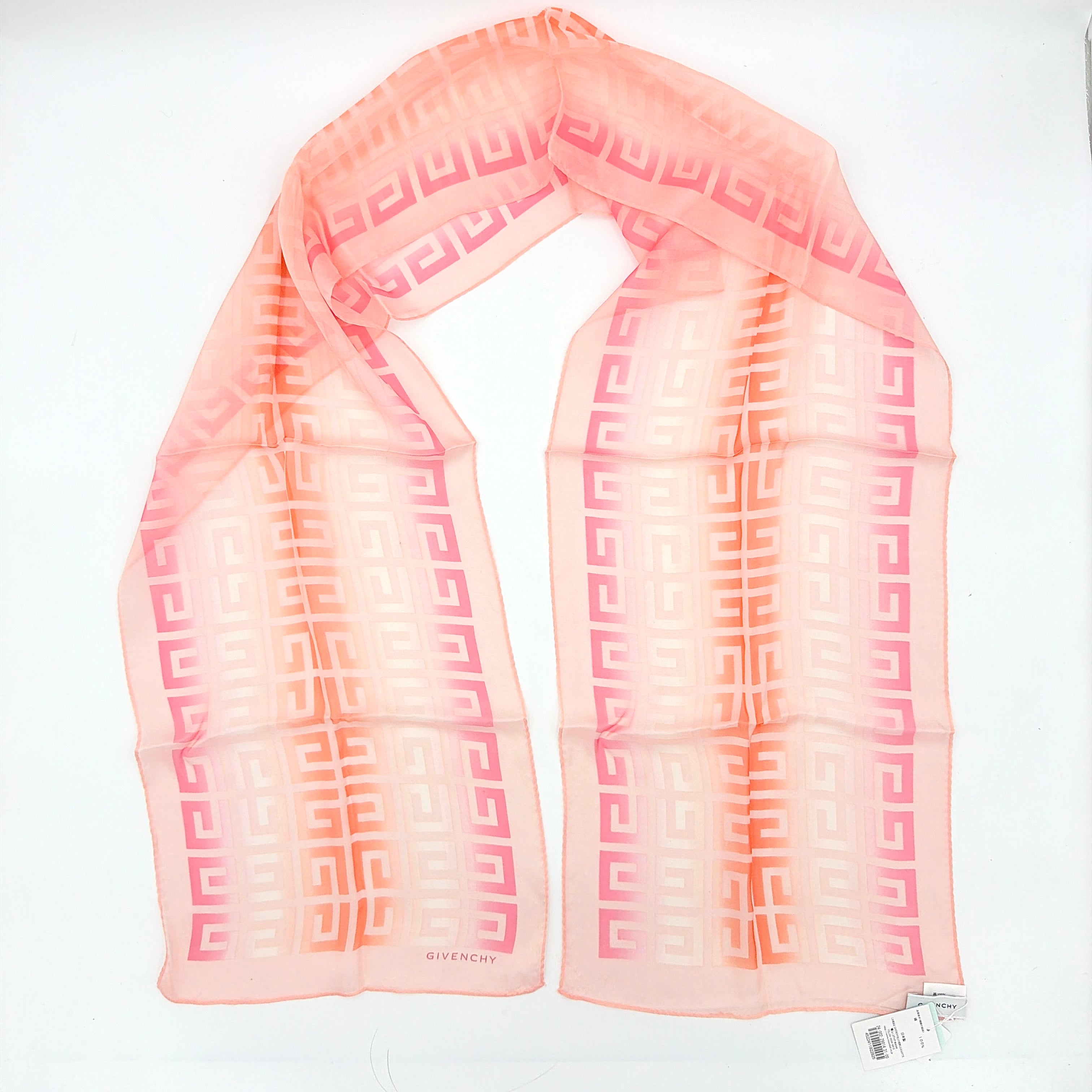 Givenchy silk scarf in pink with orange monogram pattern, showing the full length and original tags attached.