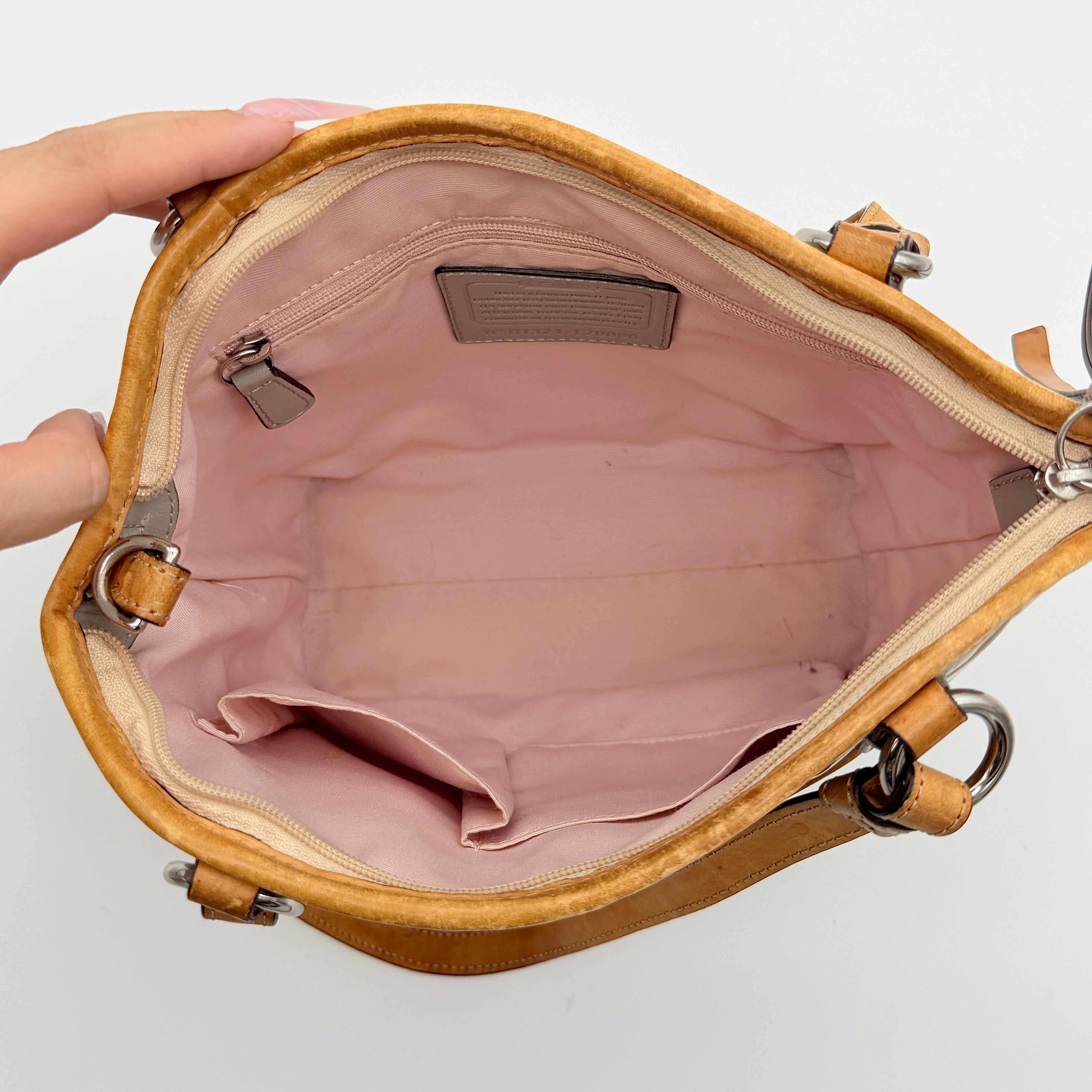 Coach Peyton embossed patent shoulder bag in yellow with tan leather trim and double handles, shown against a white background.