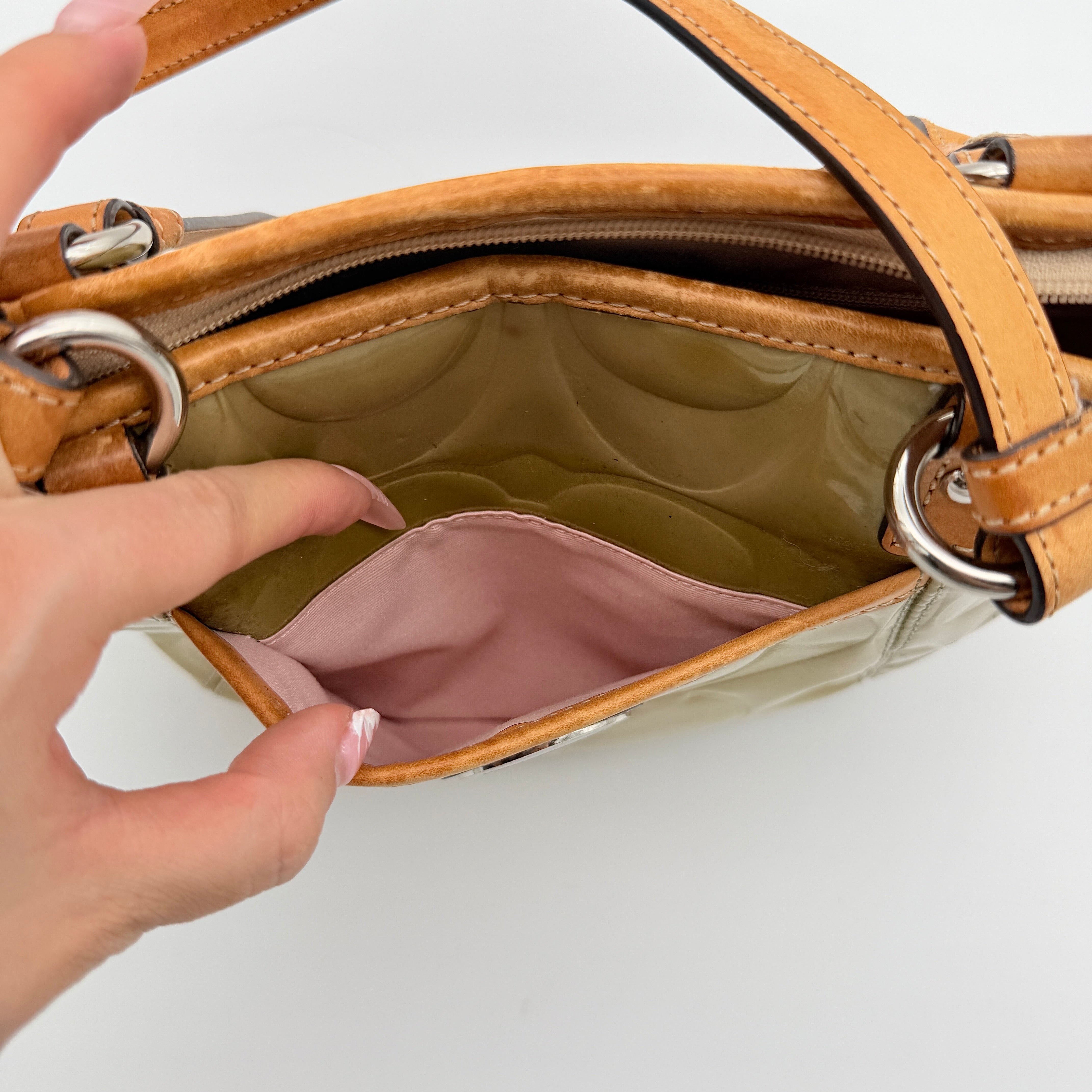 Coach Peyton embossed patent shoulder bag in yellow with tan leather trim and double handles, shown against a white background.