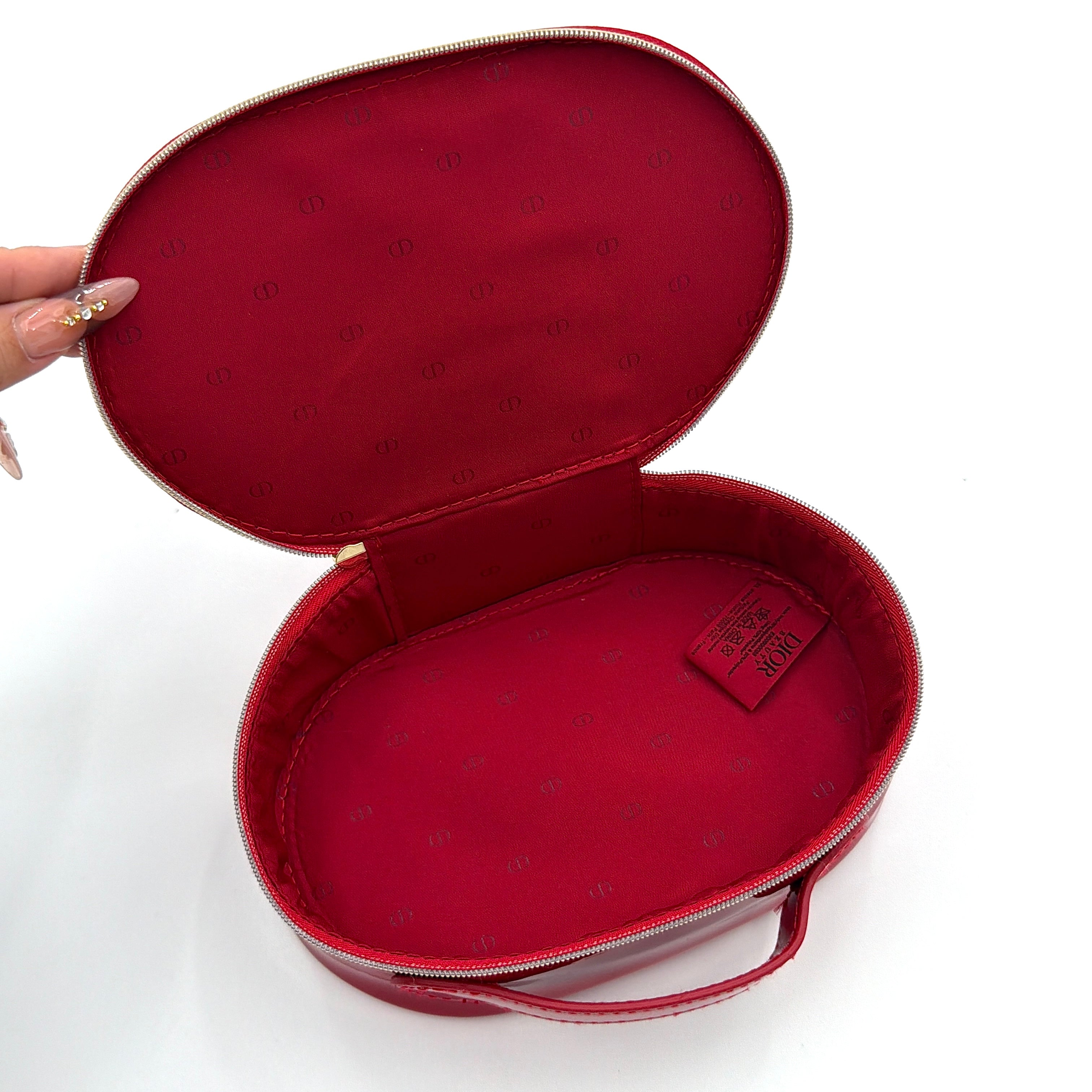 Christian Dior patent leather cosmetic pouch in glossy red with embossed DIOR logo and gold zip hardware.