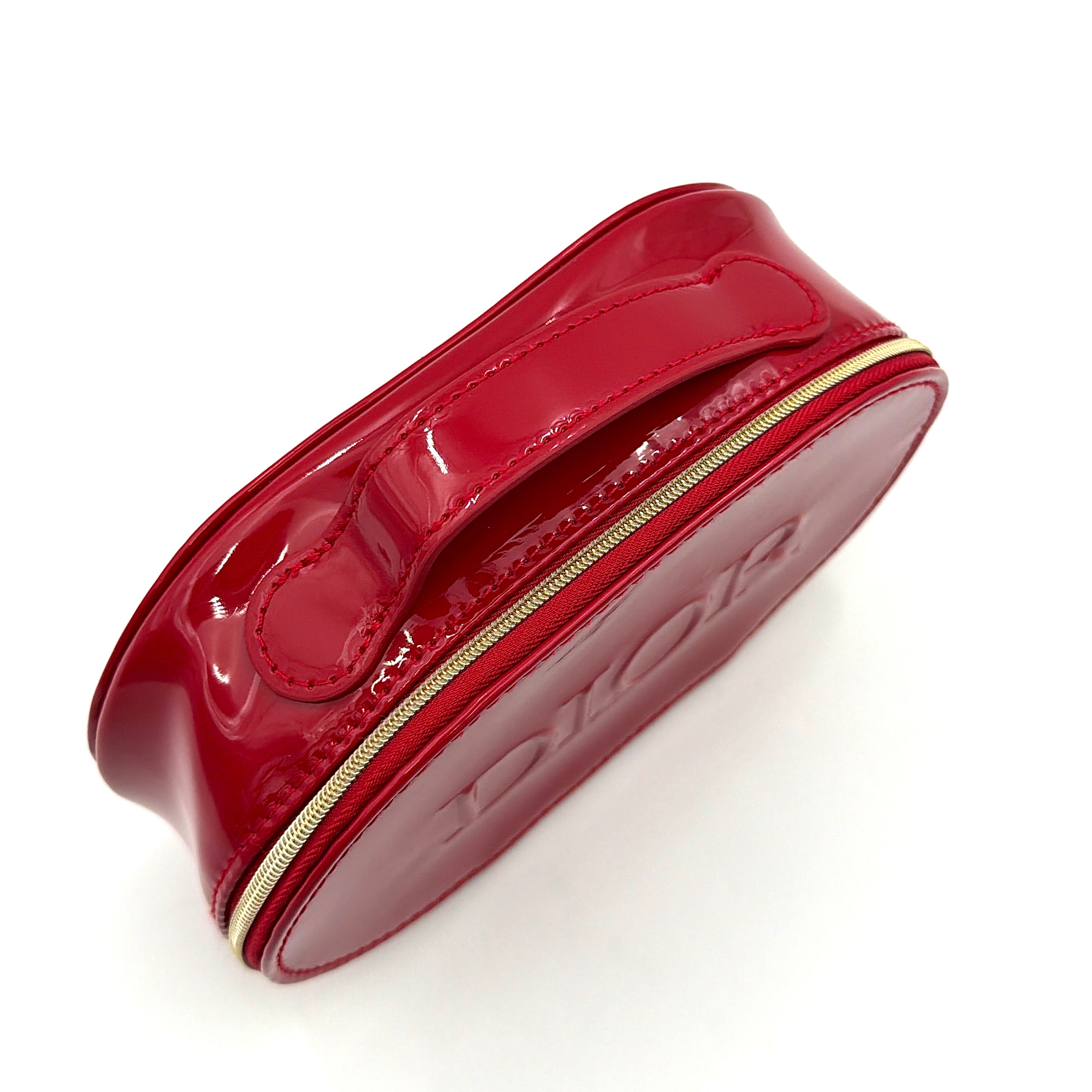 Christian Dior patent leather cosmetic pouch in glossy red with embossed DIOR logo and gold zip hardware.