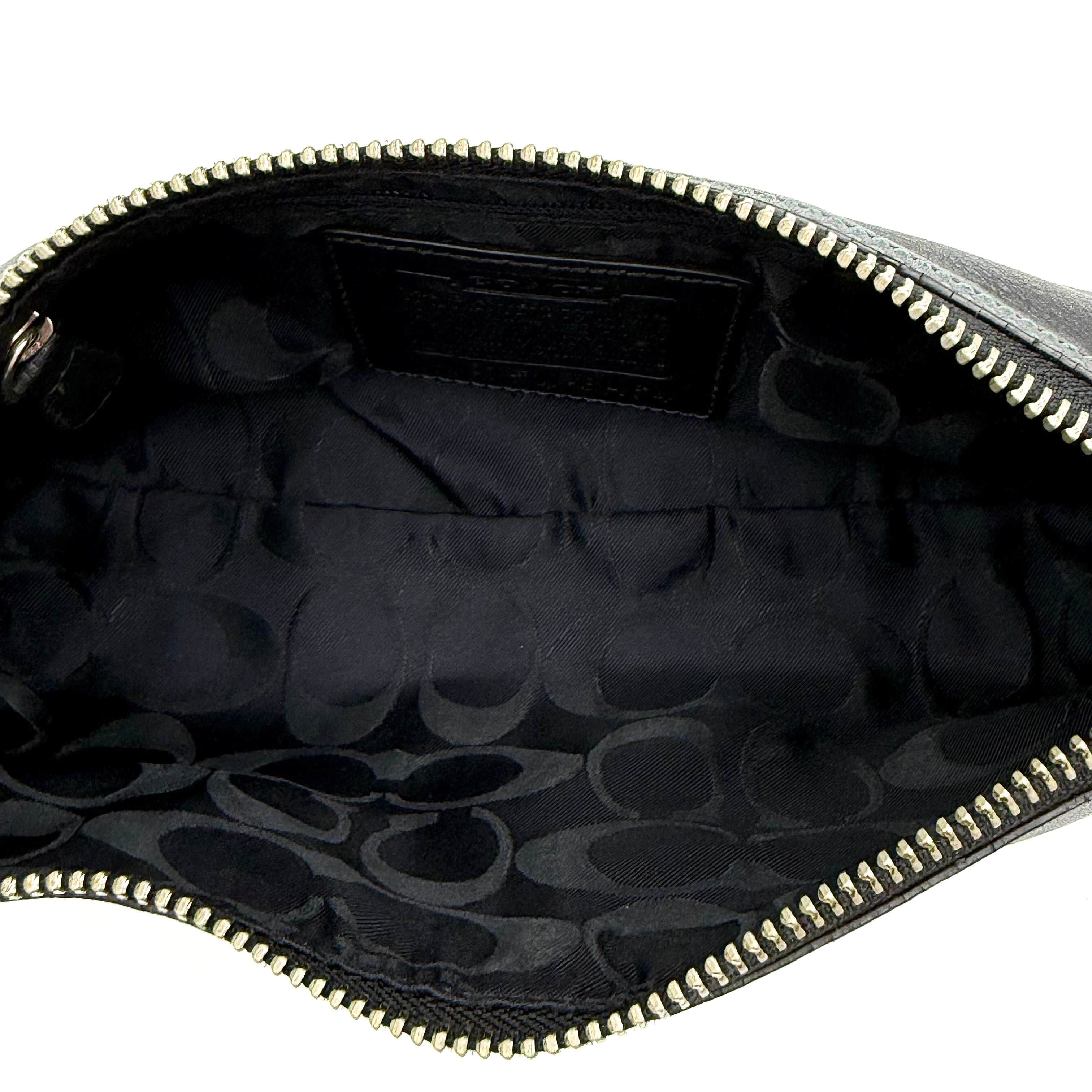 Coach Hampton Demi Baguette shoulder bag in smooth black leather with a curved top handle and silver-tone hardware.