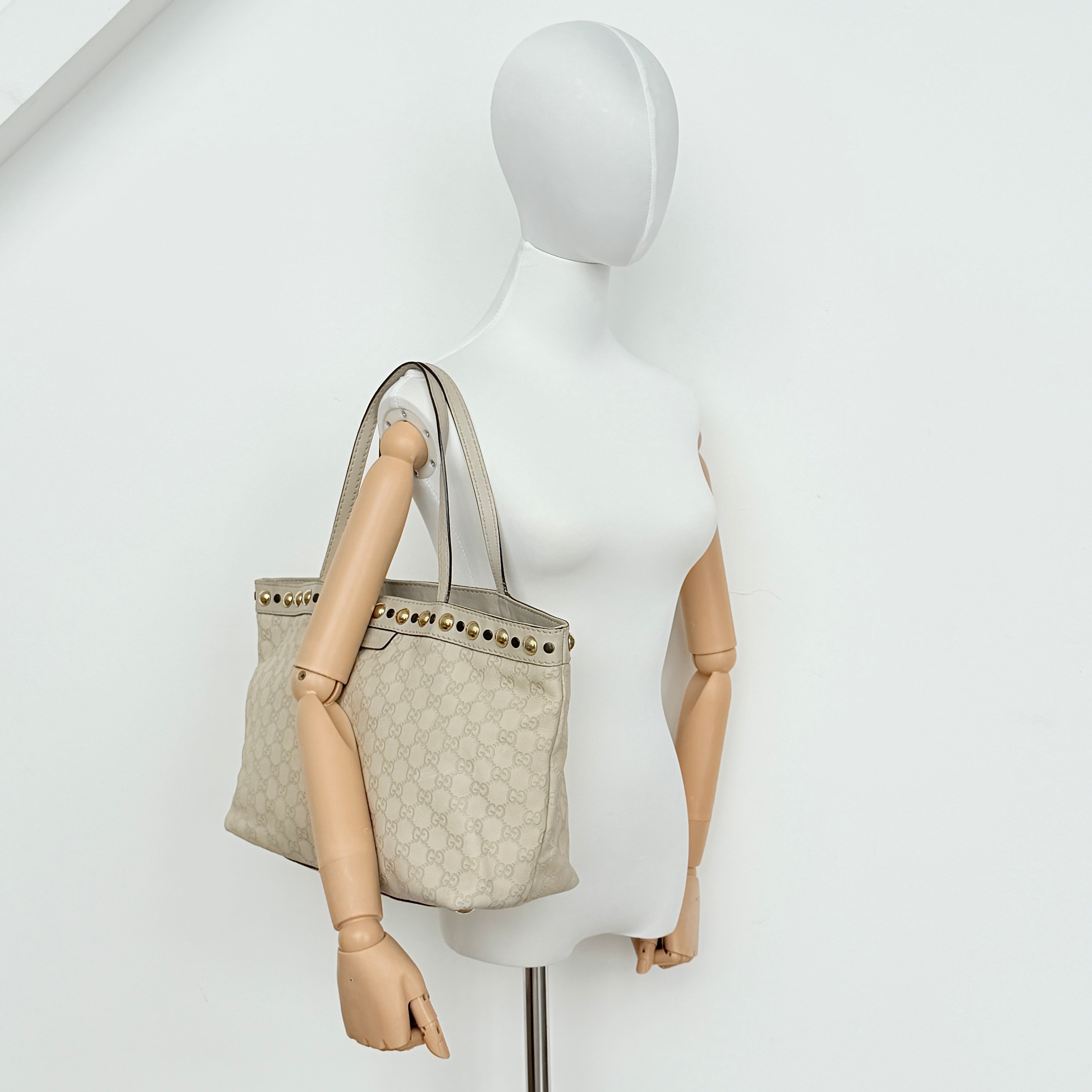 Gucci GG Monogram Babouska shoulder bag in cream canvas with gold-tone stud details and double top handles.
