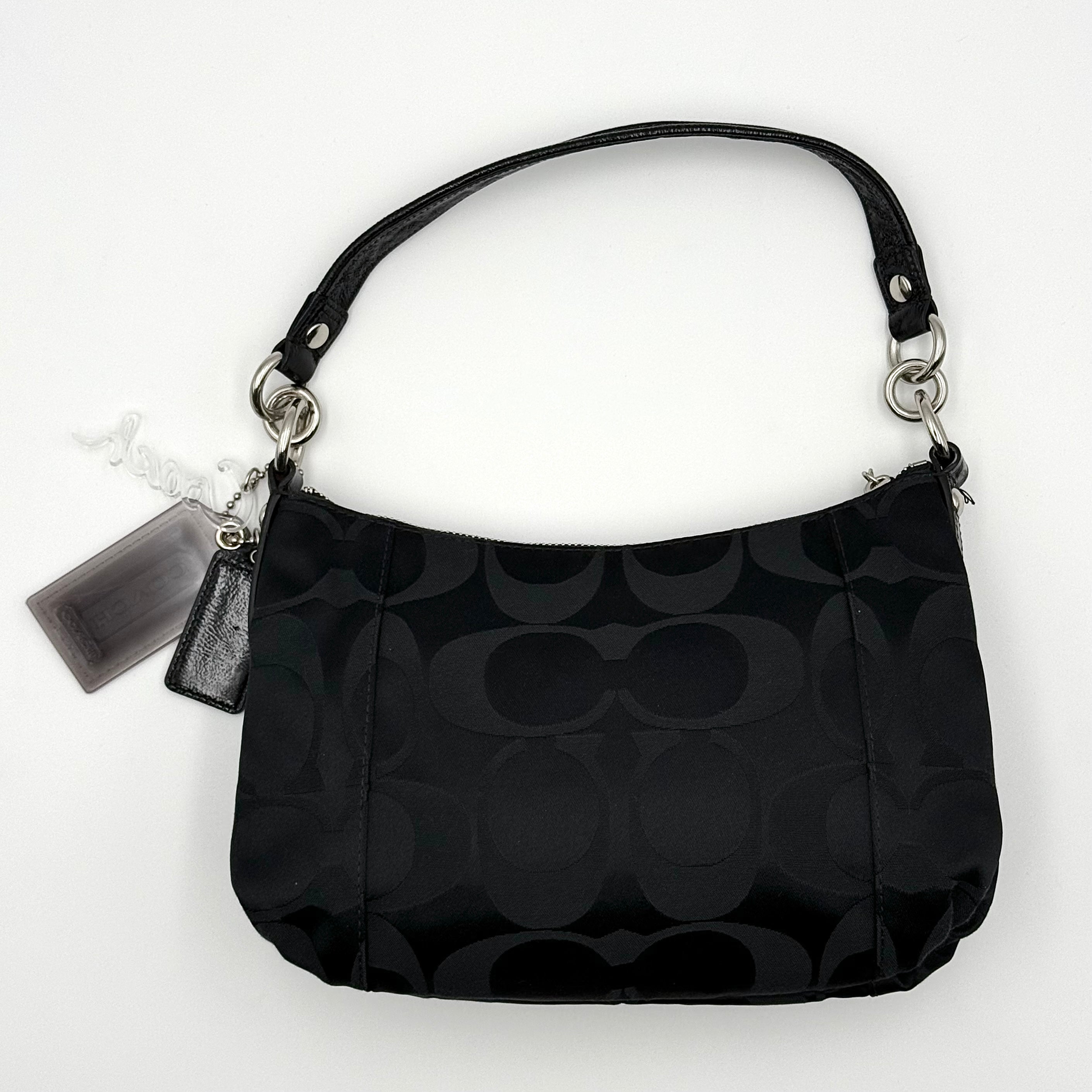 Coach black Signature Poppy Shoulder Bag with silver hardware, Coach tags, and tonal jacquard finish on a white background.