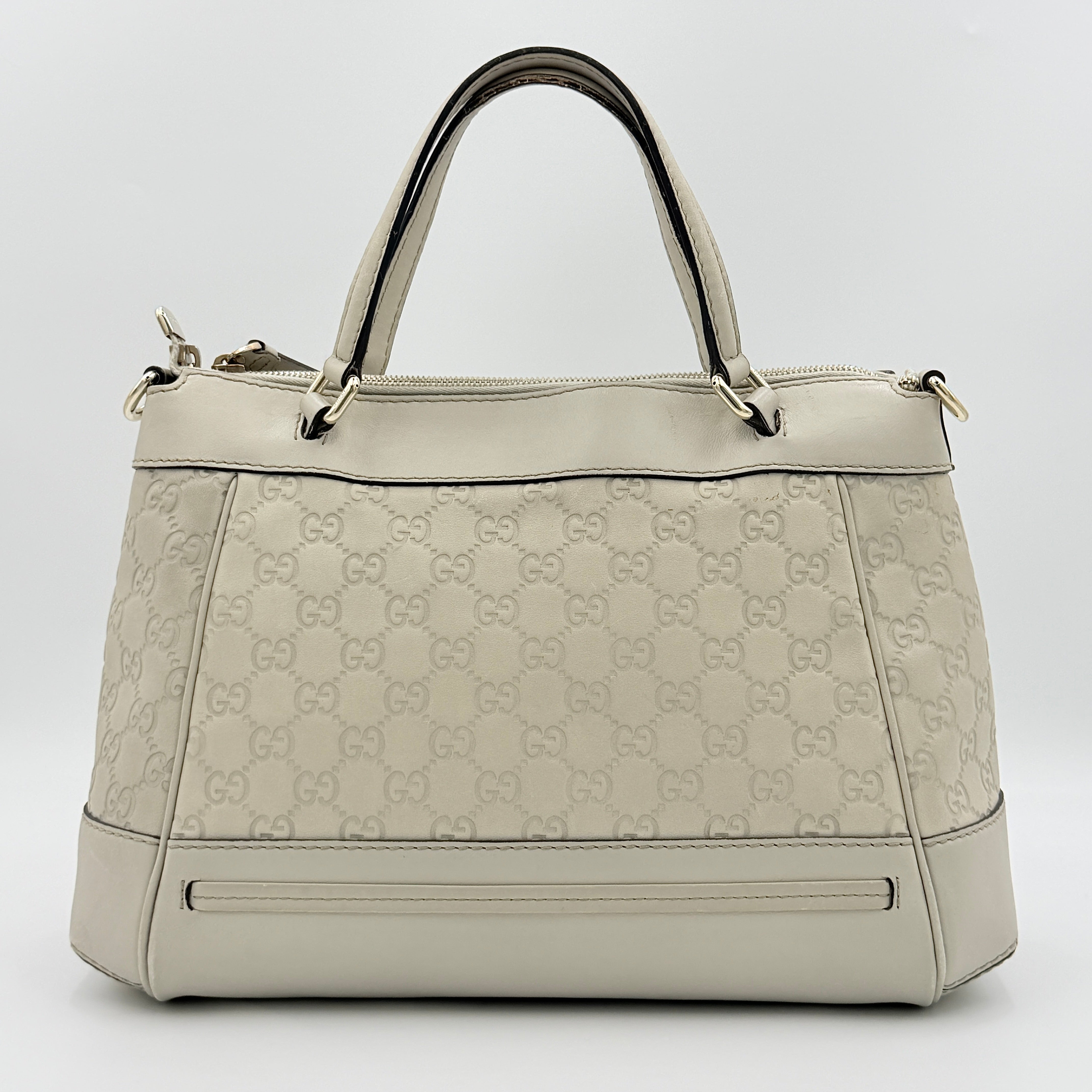 Gucci Mayfair Bow 2Way shoulder bag in cream GG monogram leather with dual handles and detachable strap, styled against a neutral backdrop.