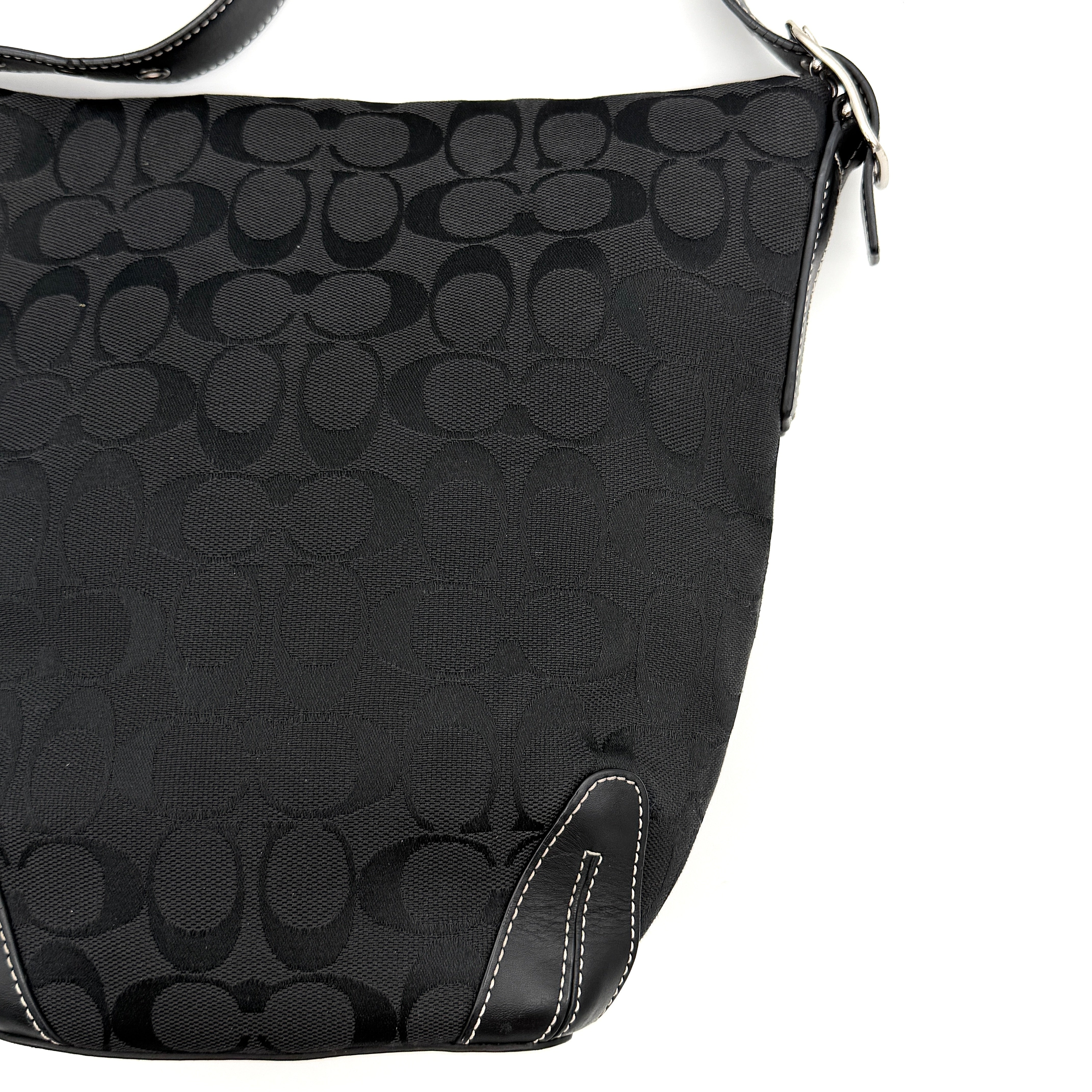 Coach black Signature Bucket Hobo bag with jacquard monogram, leather trim, and adjustable shoulder strap.