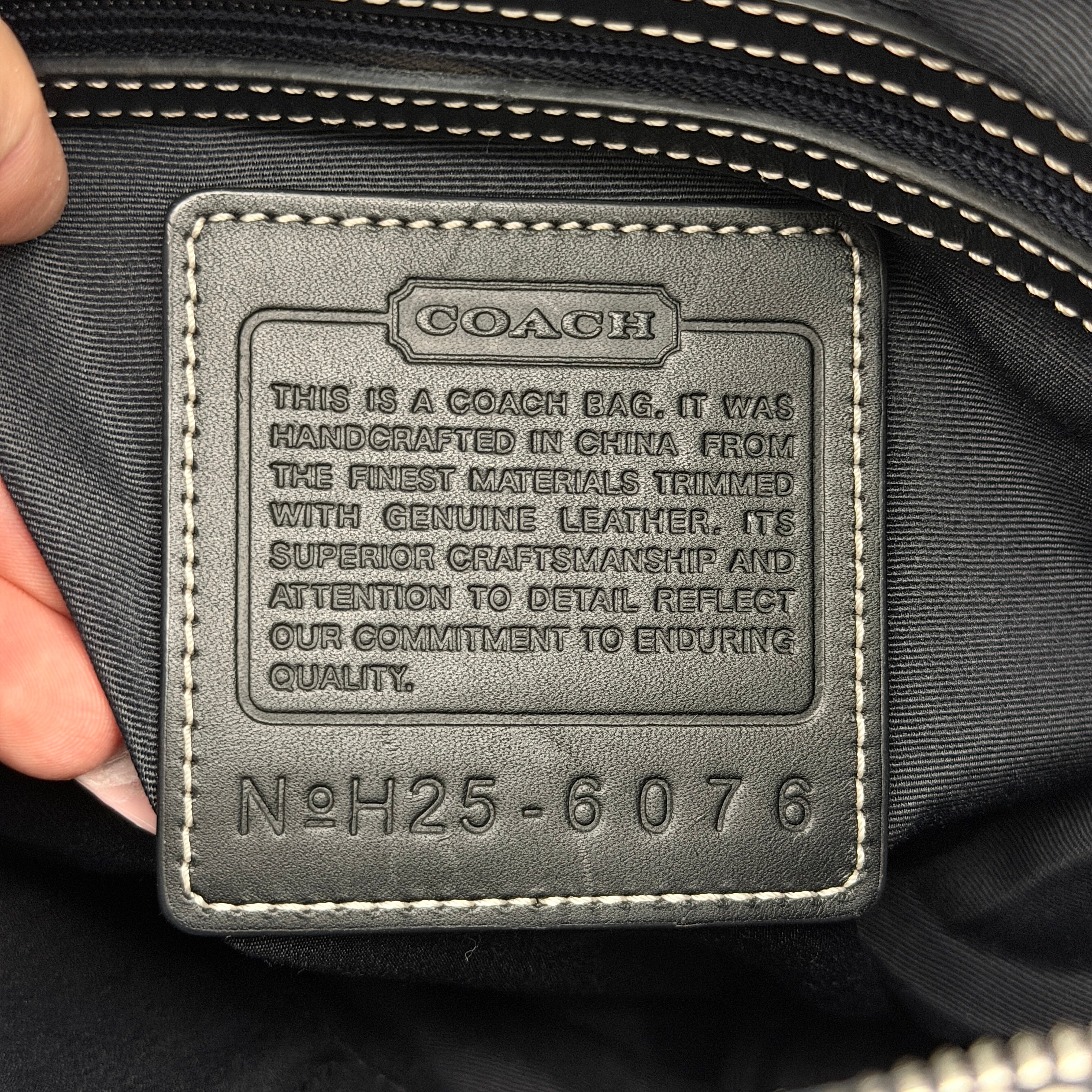 Coach black Signature Bucket Hobo bag with jacquard monogram, leather trim, and adjustable shoulder strap.