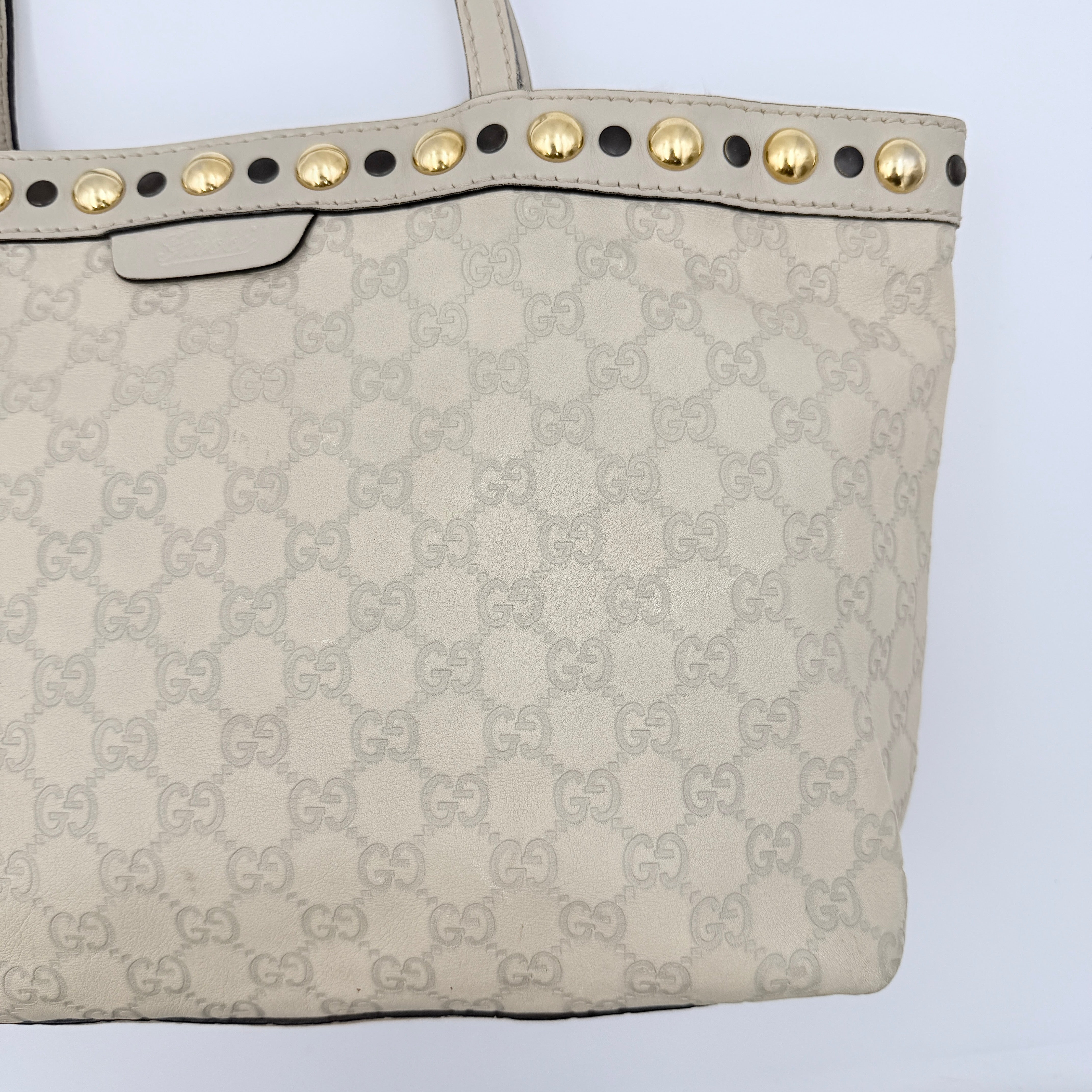 Gucci GG Monogram Babouska shoulder bag in cream canvas with gold-tone stud details and double top handles.