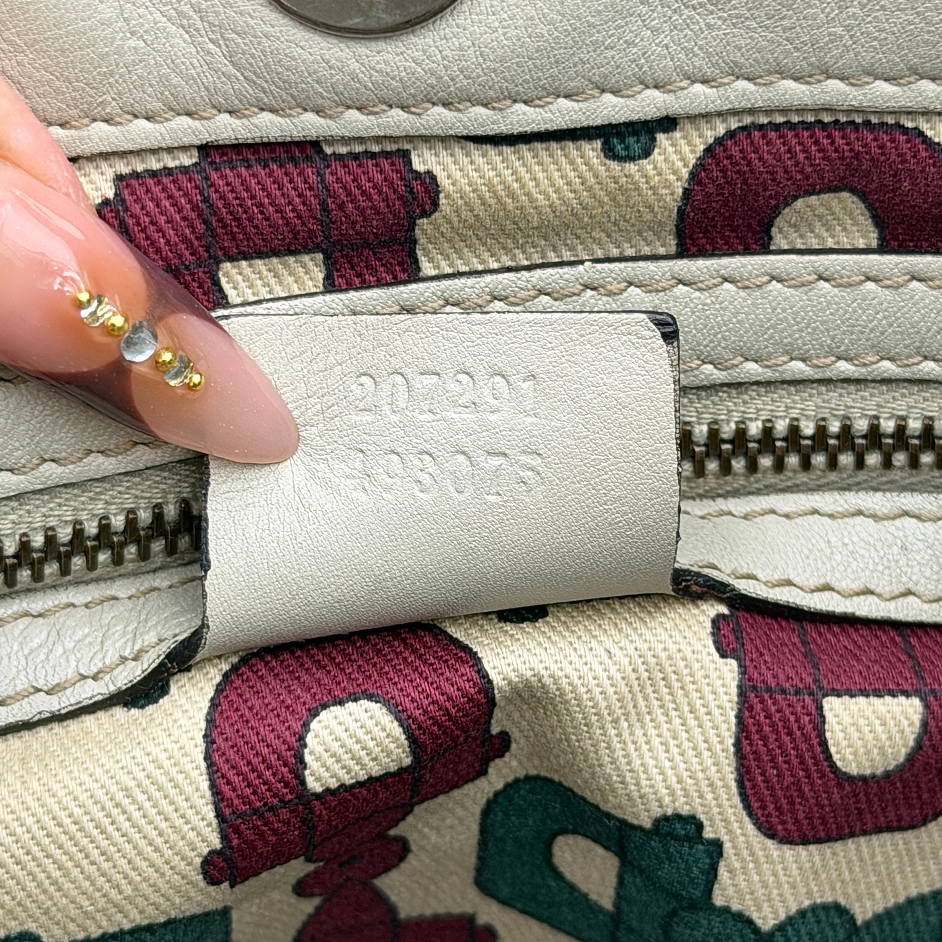 Gucci GG Monogram Babouska shoulder bag in cream canvas with gold-tone stud details and double top handles.