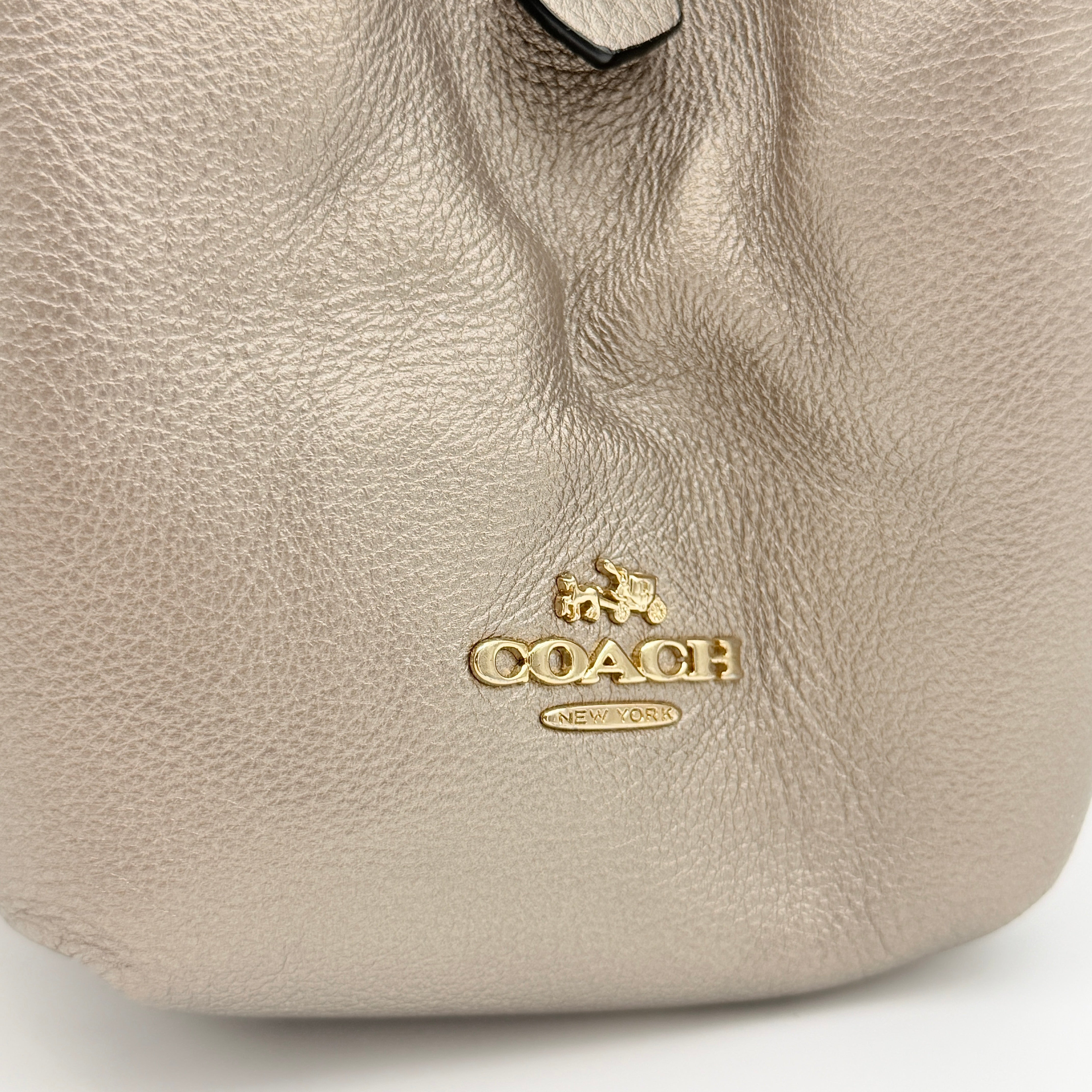 Coach Madison Phoebe shoulder bag in metallic taupe pebbled leather with dual straps and gold-tone hardware.