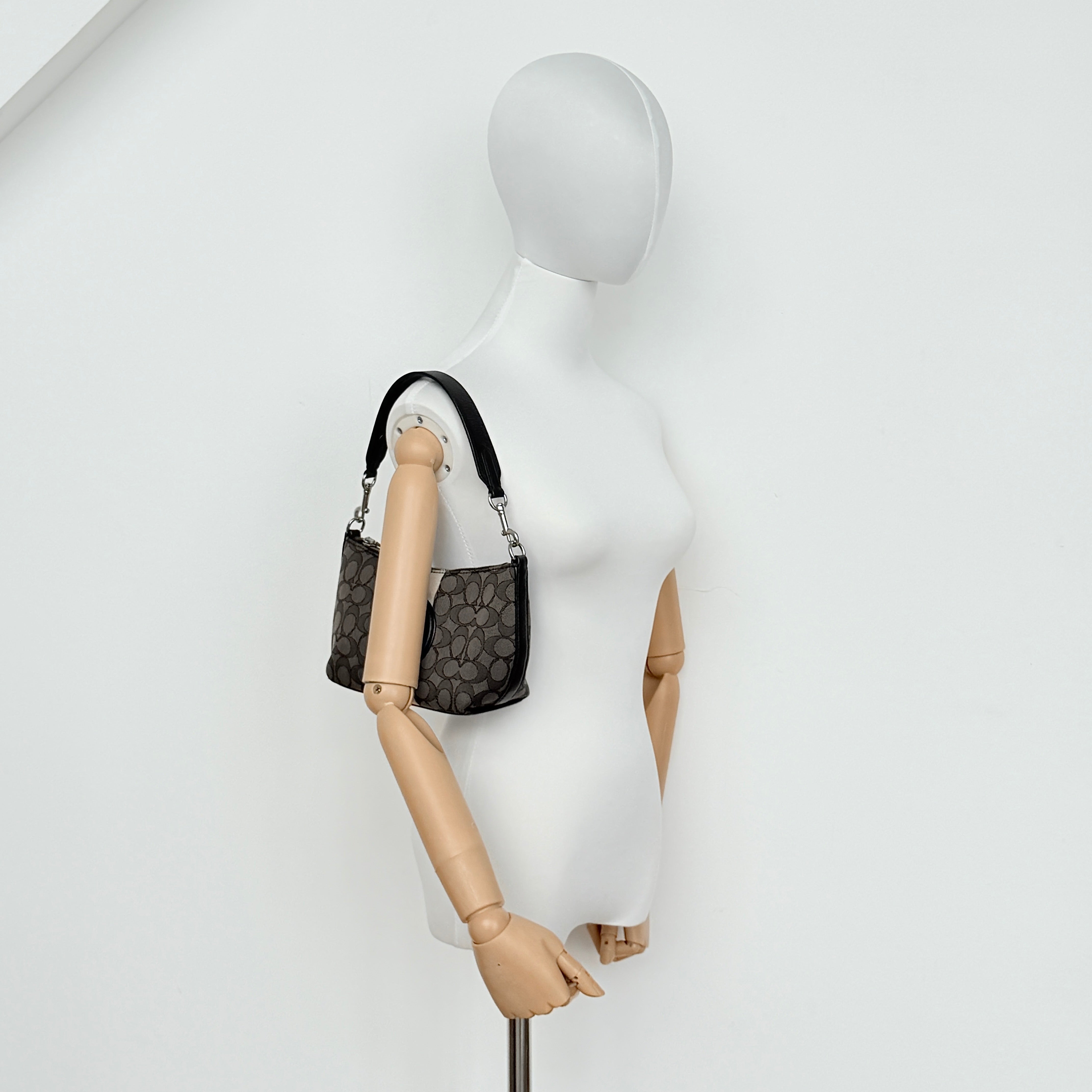 The Coach 2Way Signature Dempsey Stripe Shoulder Bag in black and grey canvas with detachable straps, shown flat on a white background.