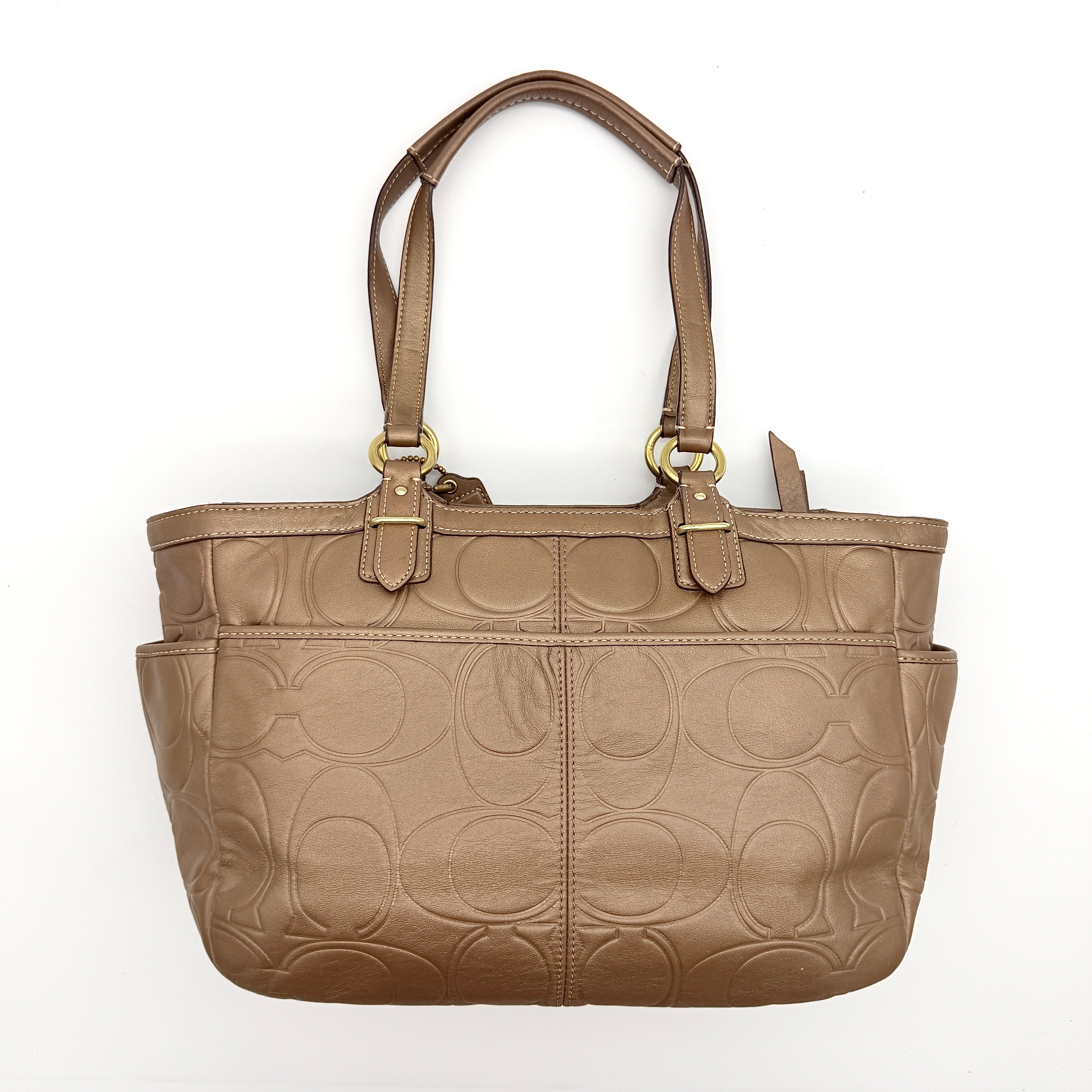 Coach Signature Gallery embossed leather tote bag in brown with gold tone hardware and dual handles.