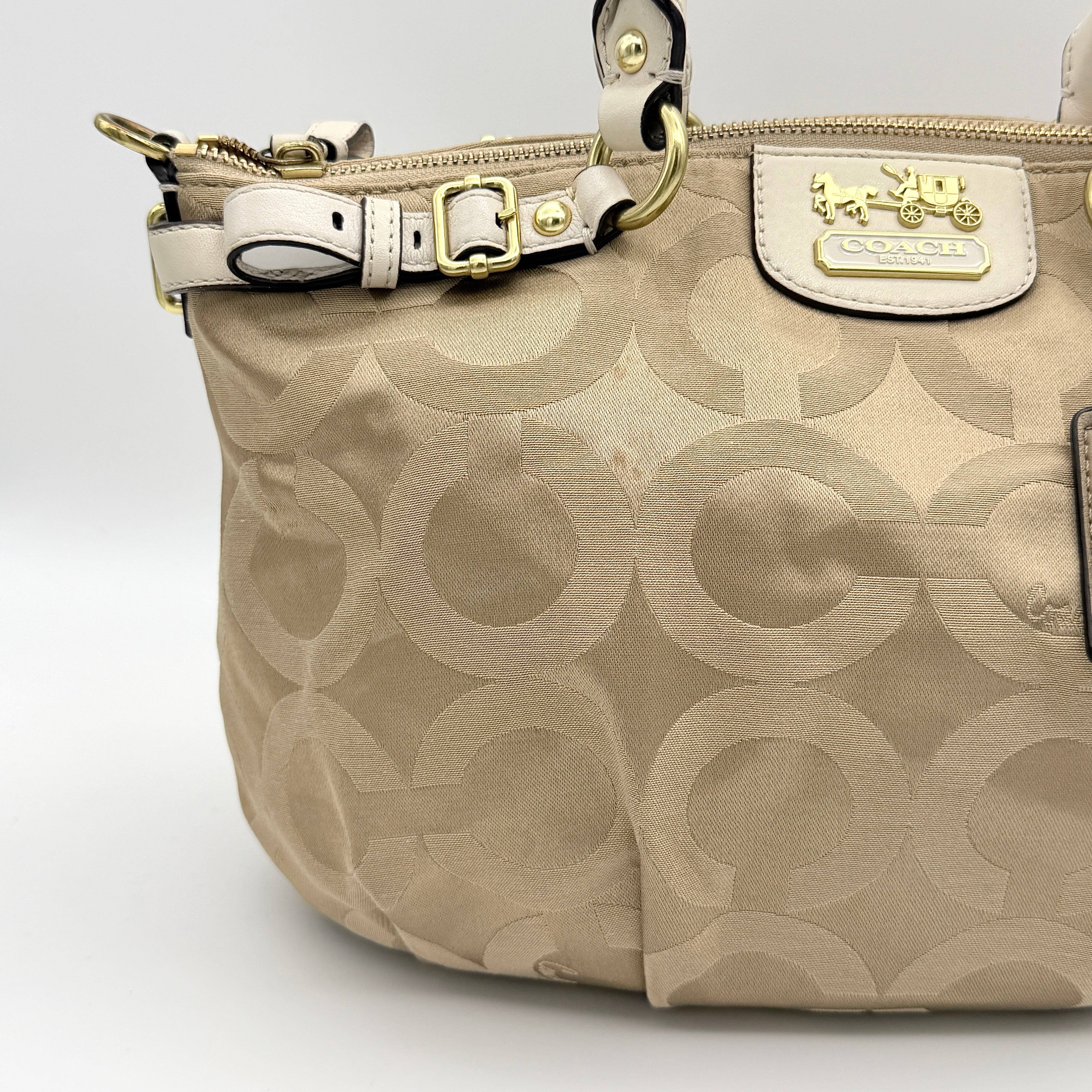 Beige Coach Madison Op Art Sophia shoulder bag with ivory leather handles, gold hardware, and detachable strap.