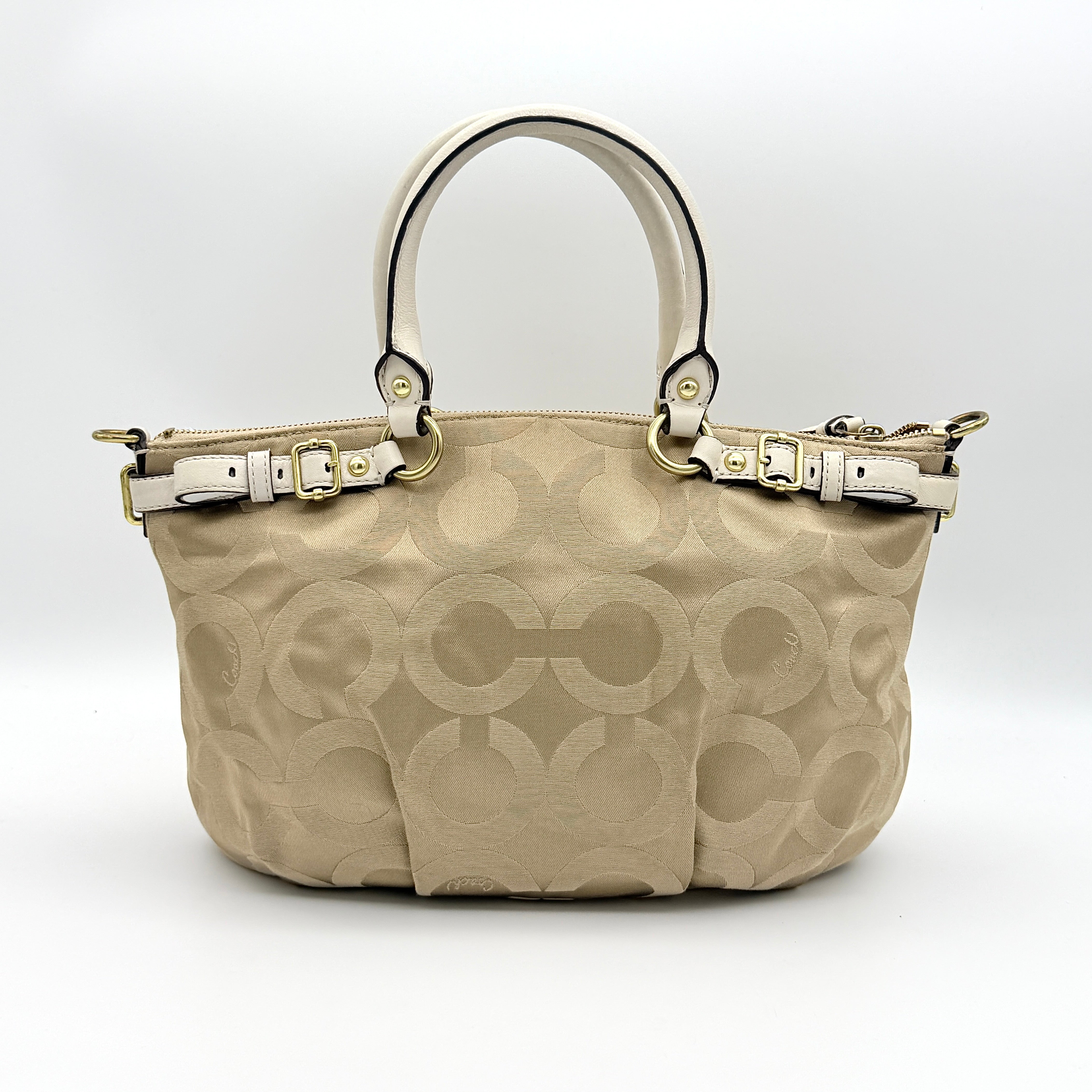 Beige Coach Madison Op Art Sophia shoulder bag with ivory leather handles, gold hardware, and detachable strap.
