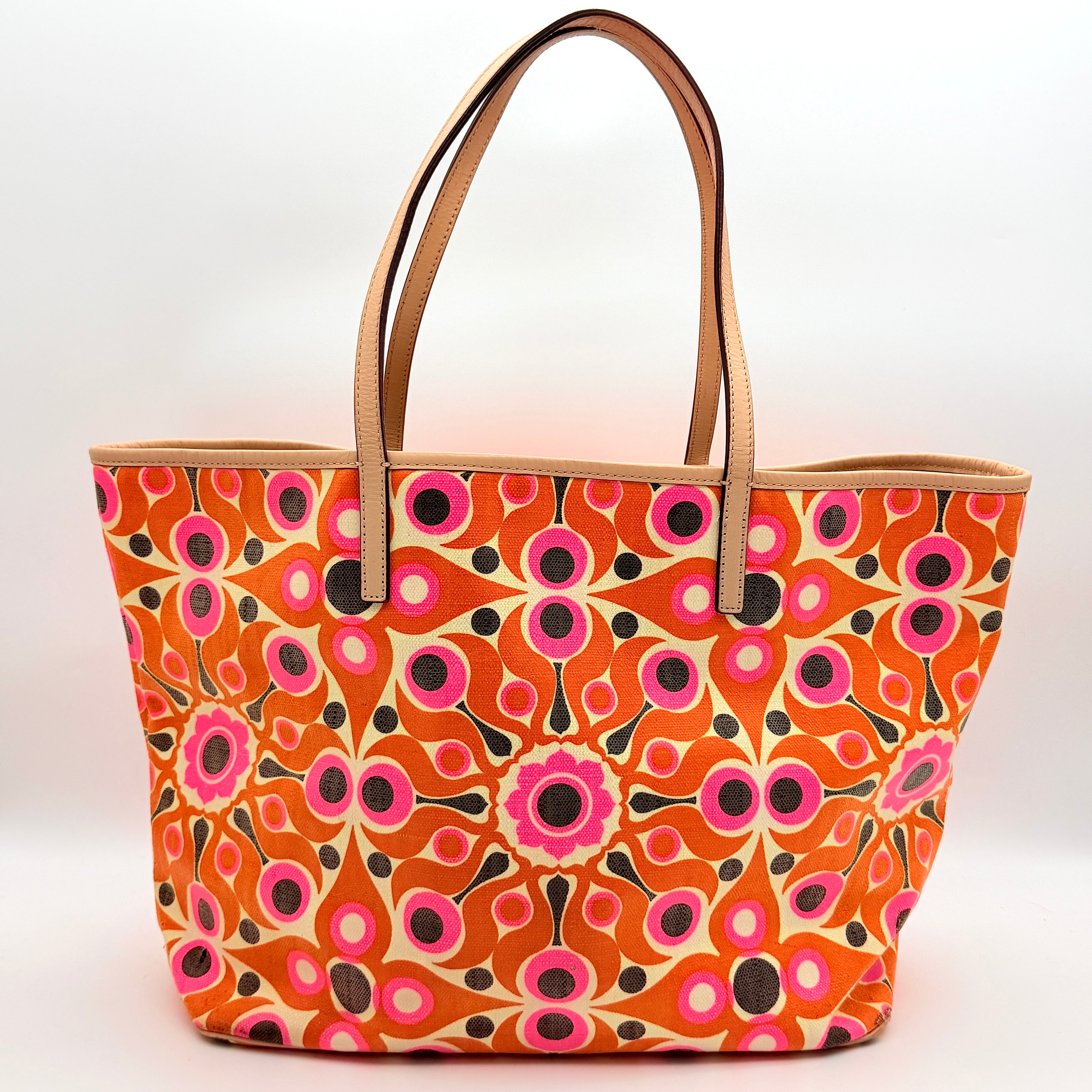 Kate Spade New York tote bag in a bold multicolour geometric pattern with beige leather handles, displayed upright against a white background.