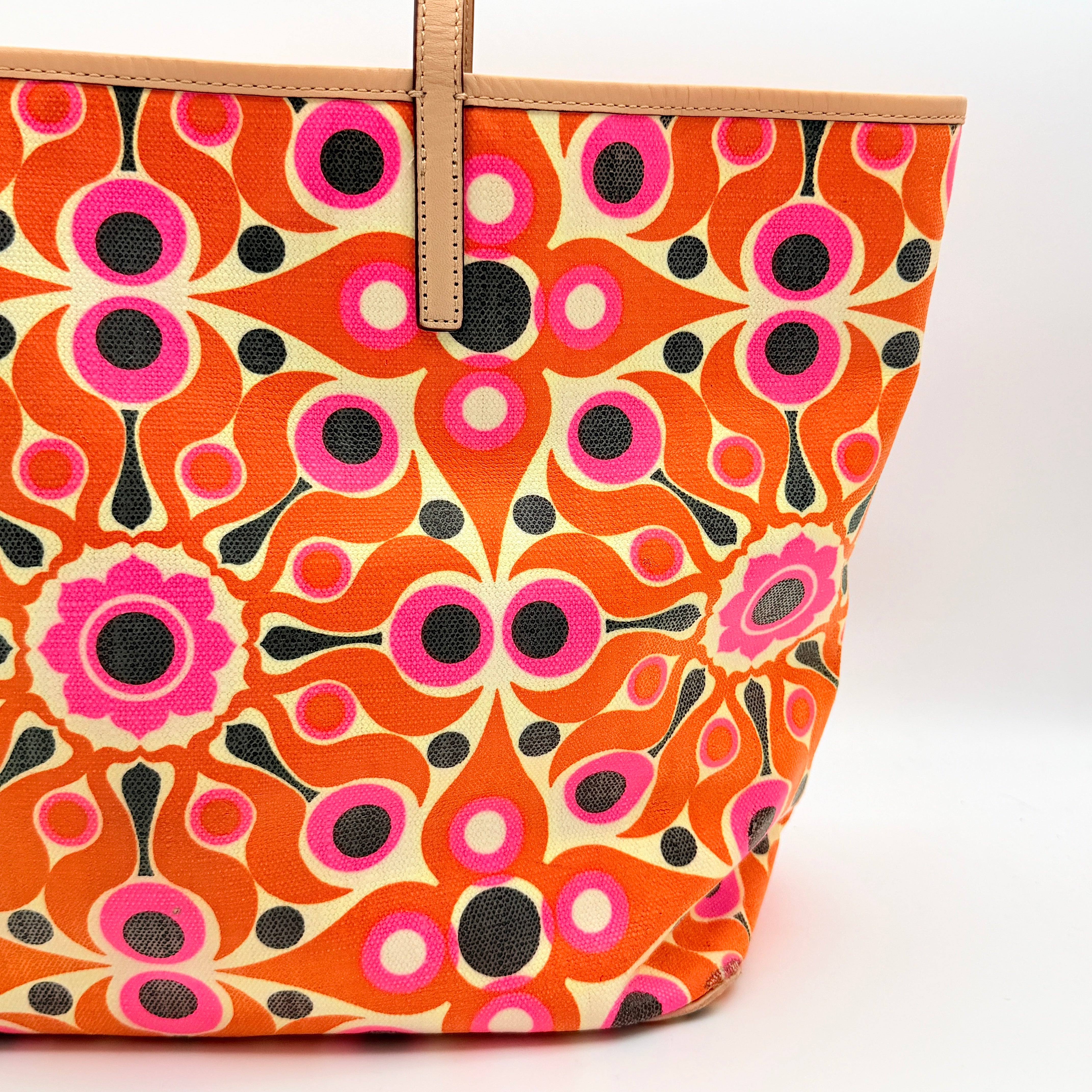 Kate Spade New York tote bag in a bold multicolour geometric pattern with beige leather handles, displayed upright against a white background.