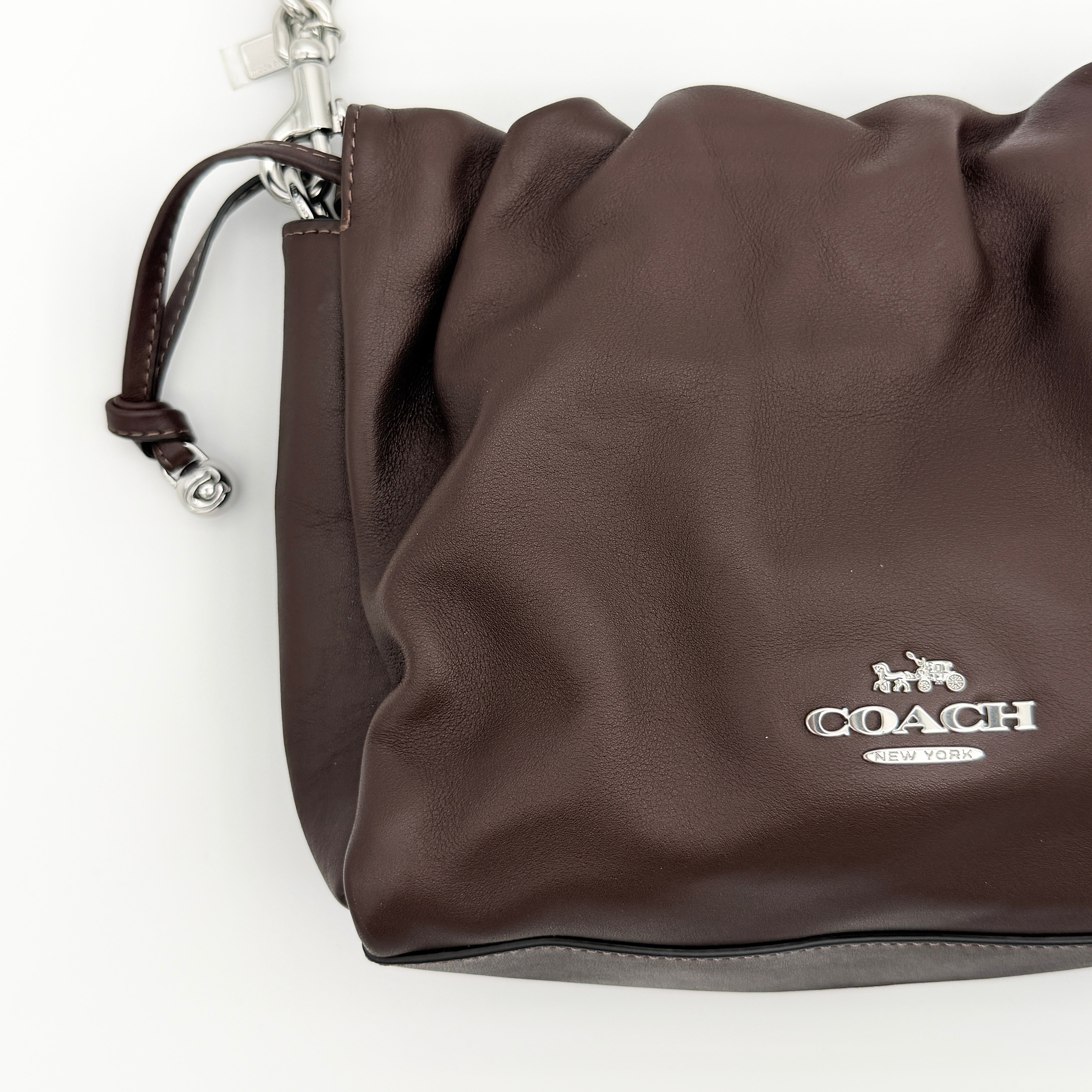 Coach Faye shoulder bag in brown leather with chunky silver-tone chain handle and detachable strap, displayed against a white background.