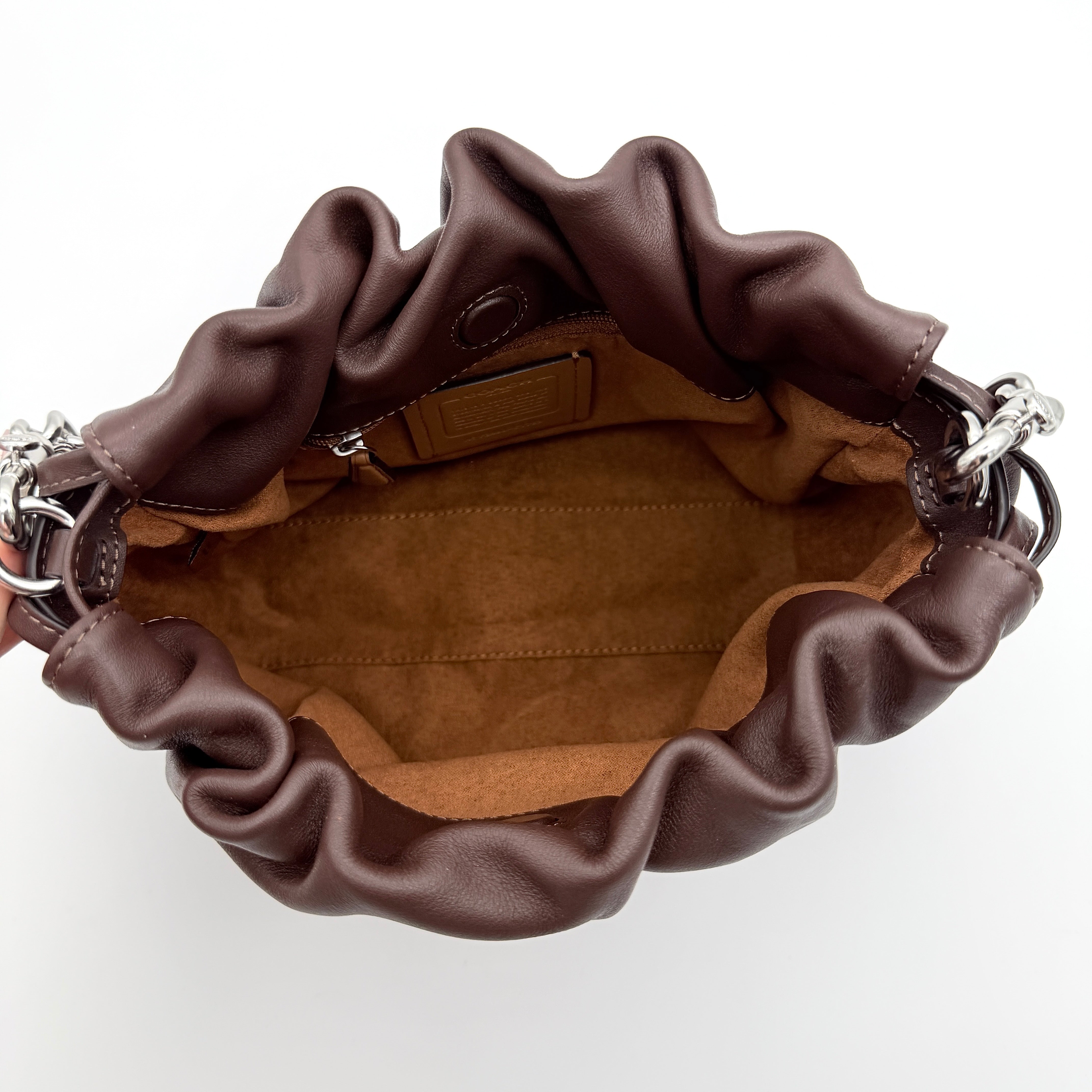 Coach Faye shoulder bag in brown leather with chunky silver-tone chain handle and detachable strap, displayed against a white background.
