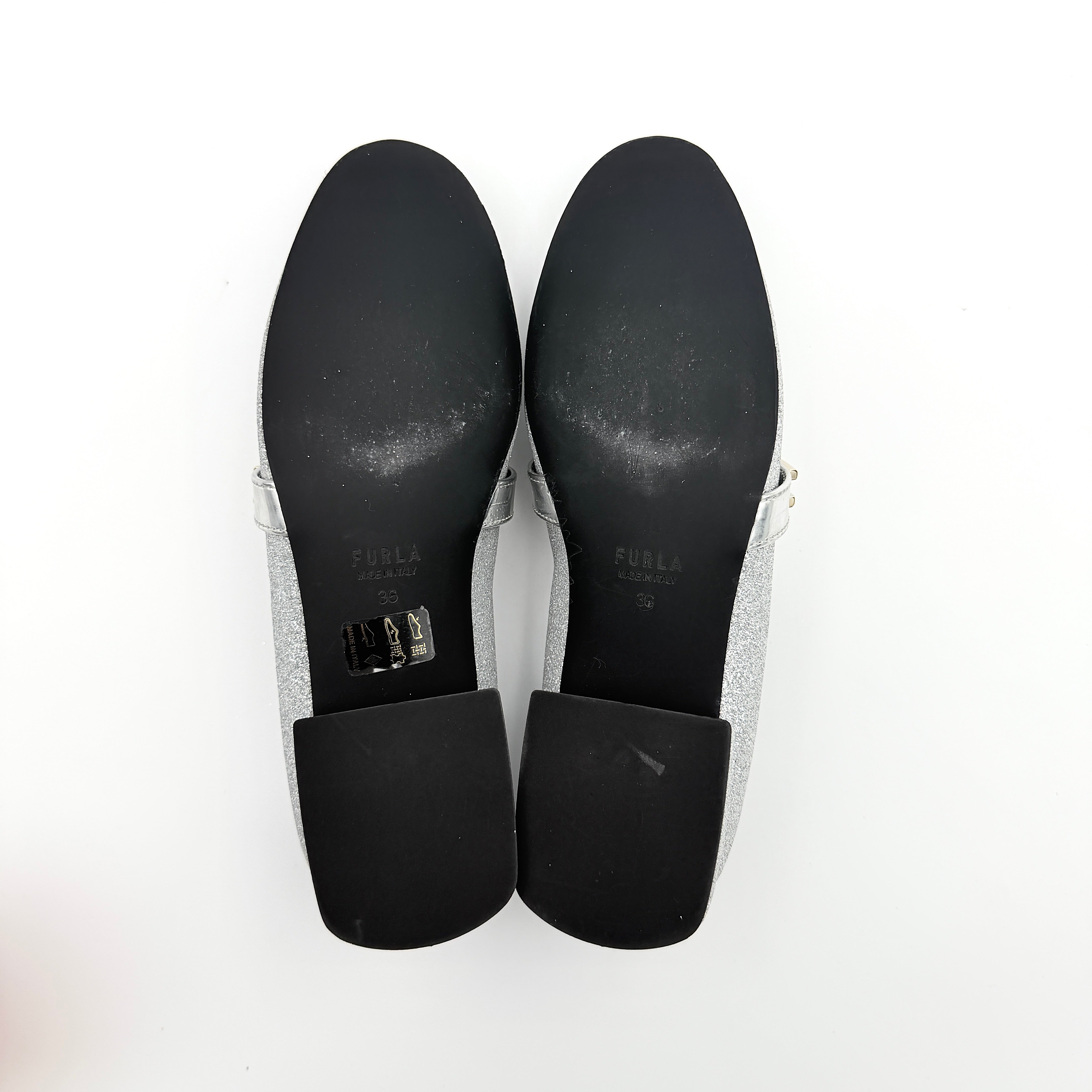 Furla 1927 T.20 loafers in silver microglitter with metallic strap and gold-tone detail, displayed in a three-quarter view.