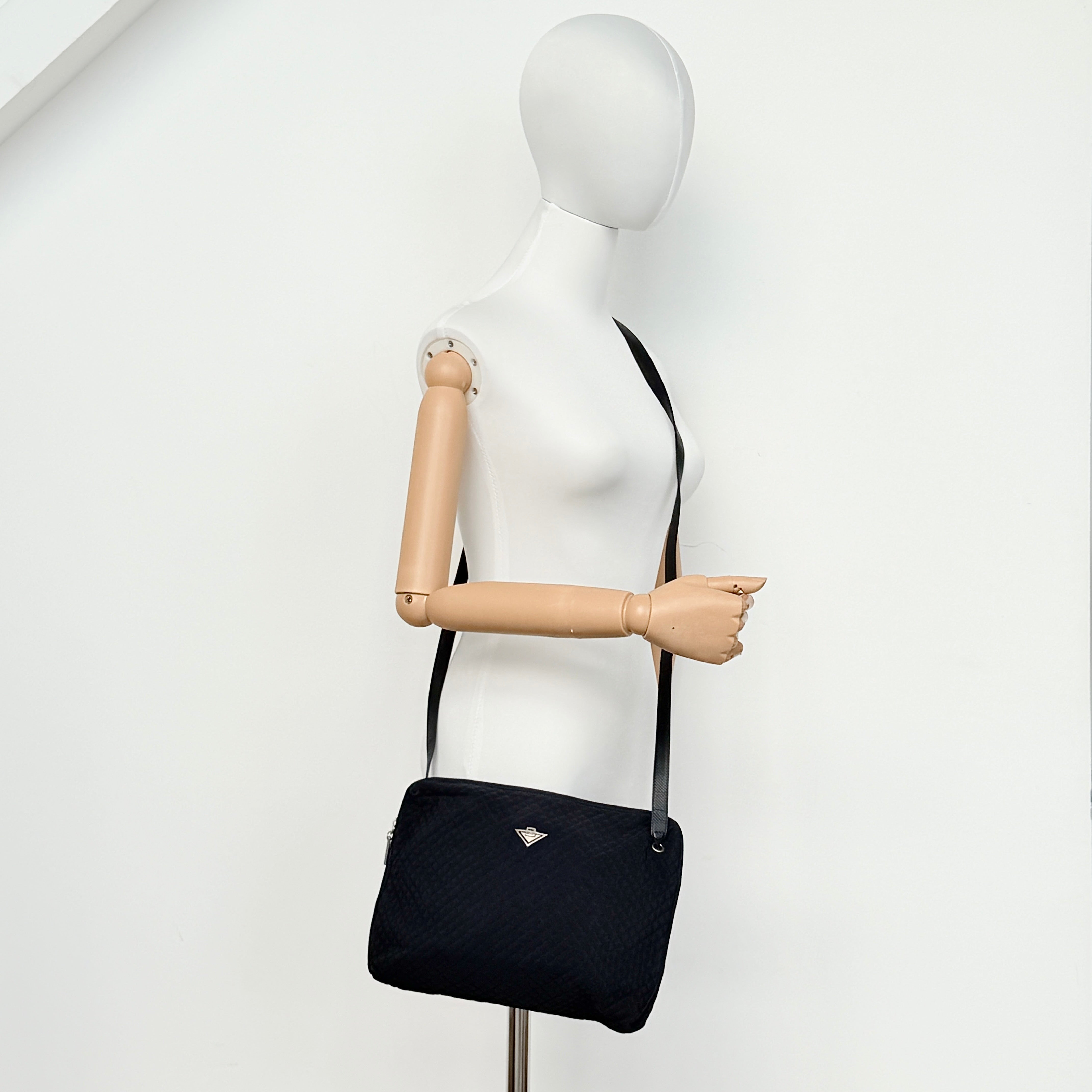 Bottega Veneta black quilted nylon crossbody bag with silver-tone logo hardware and leather strap.