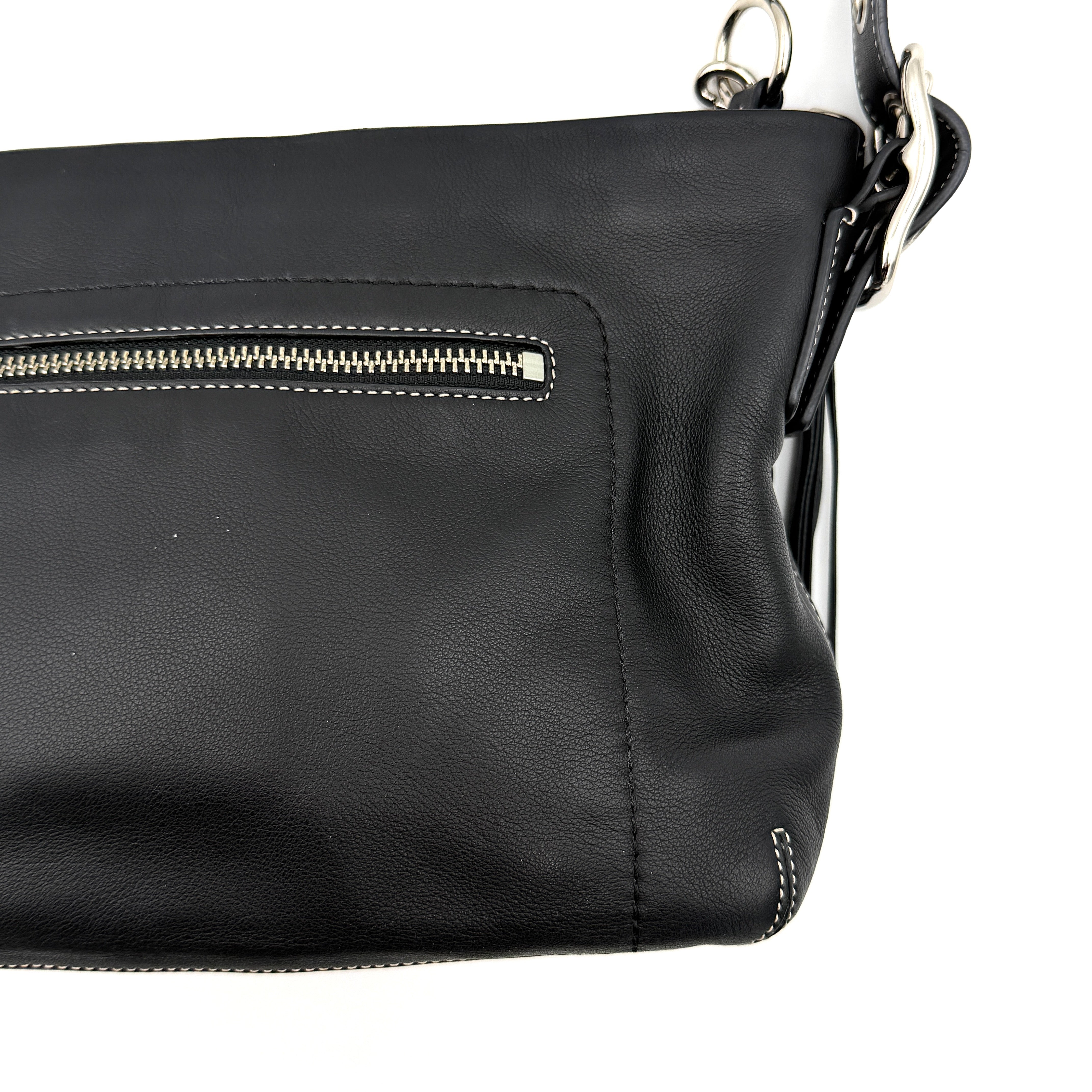 Coach Signature East West Shoulder Bag in black leather with silver hardware and contrast stitching, displayed on a white background.