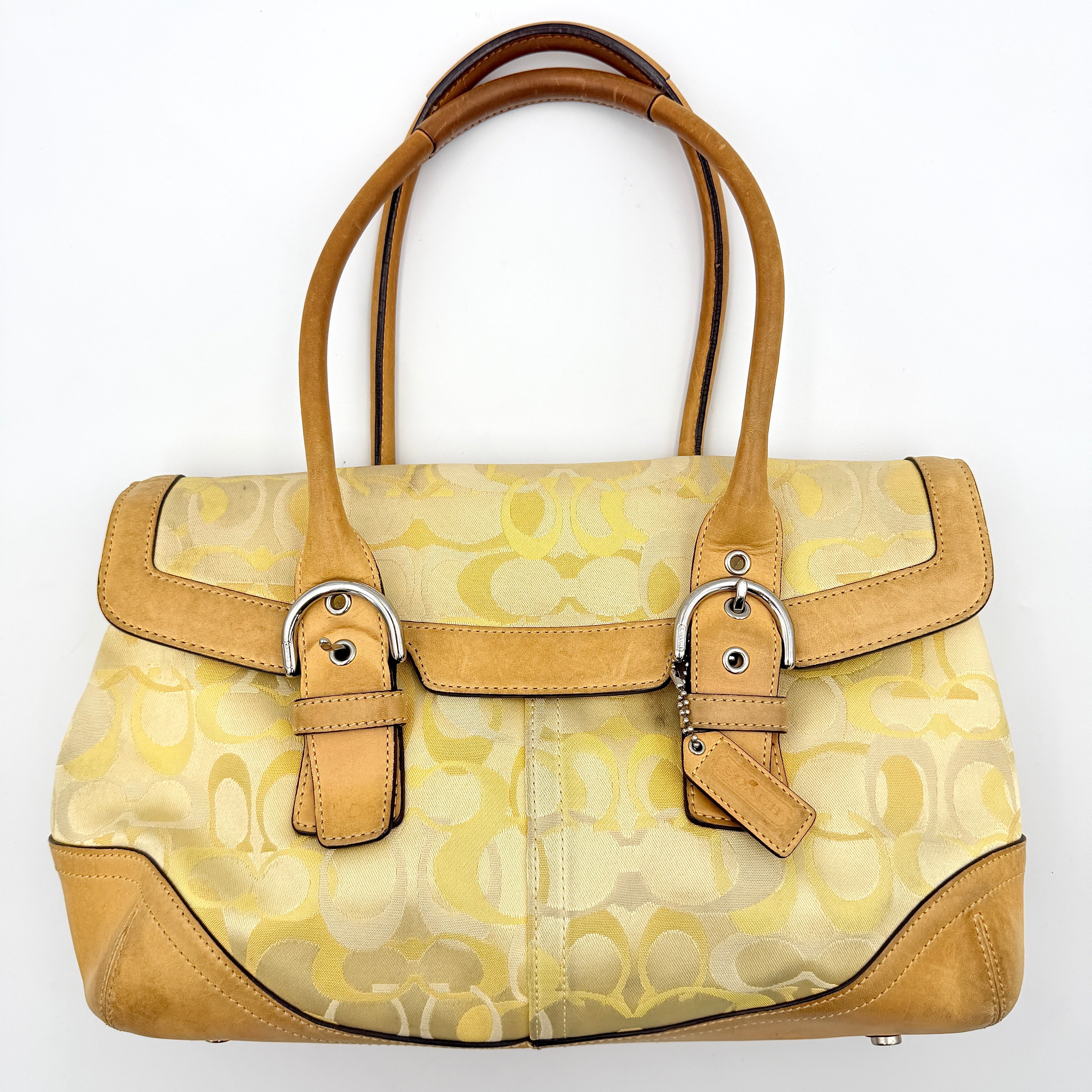 Coach Soho shoulder bag in yellow signature optic fabric with tan leather trim and silver hardware, shown with double handles.