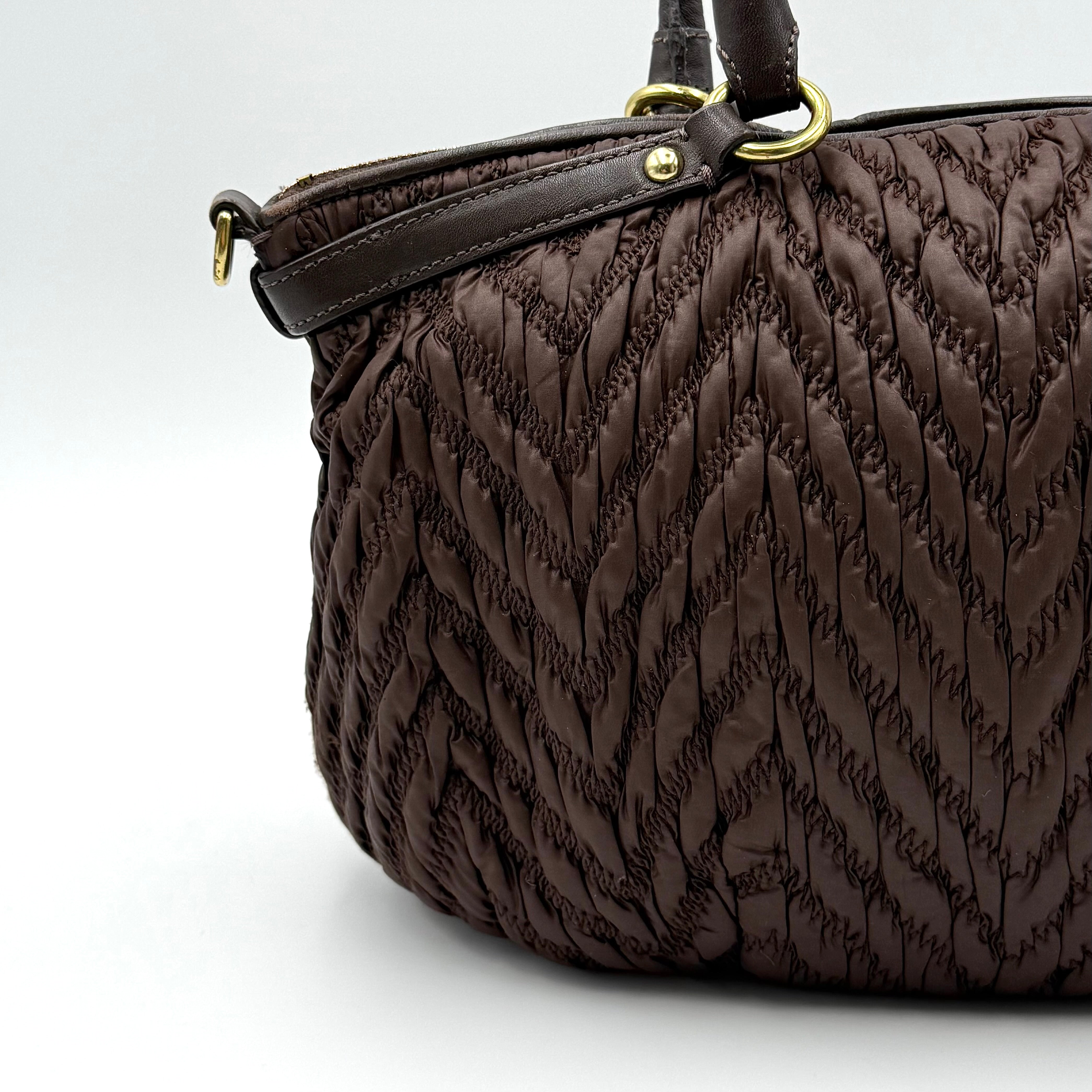 Front view of the Coach Madison Chevron 2Way brown quilted nylon shoulder bag with rolled leather handles and gold-tone hardware.