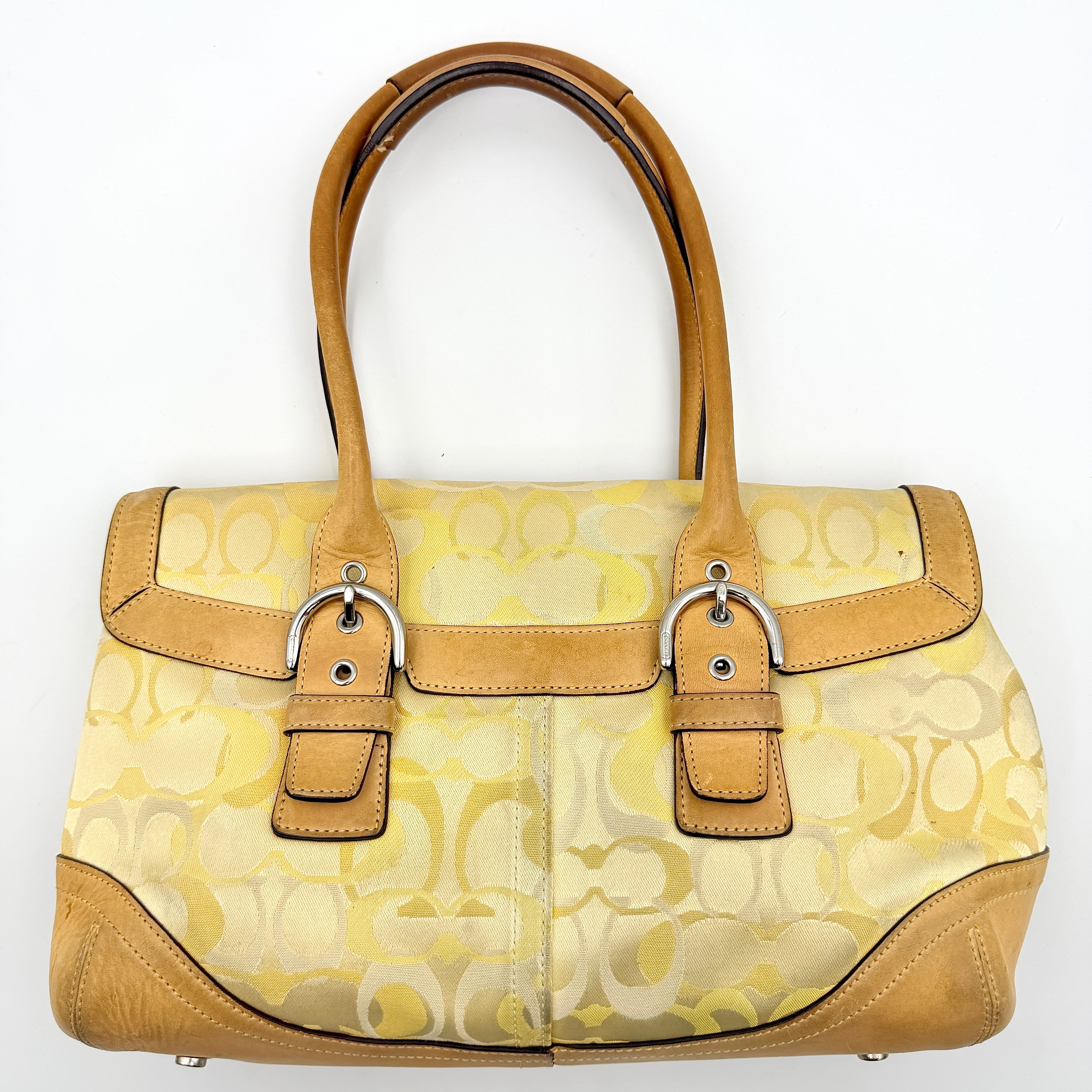 Coach Soho shoulder bag in yellow signature optic fabric with tan leather trim and silver hardware, shown with double handles.