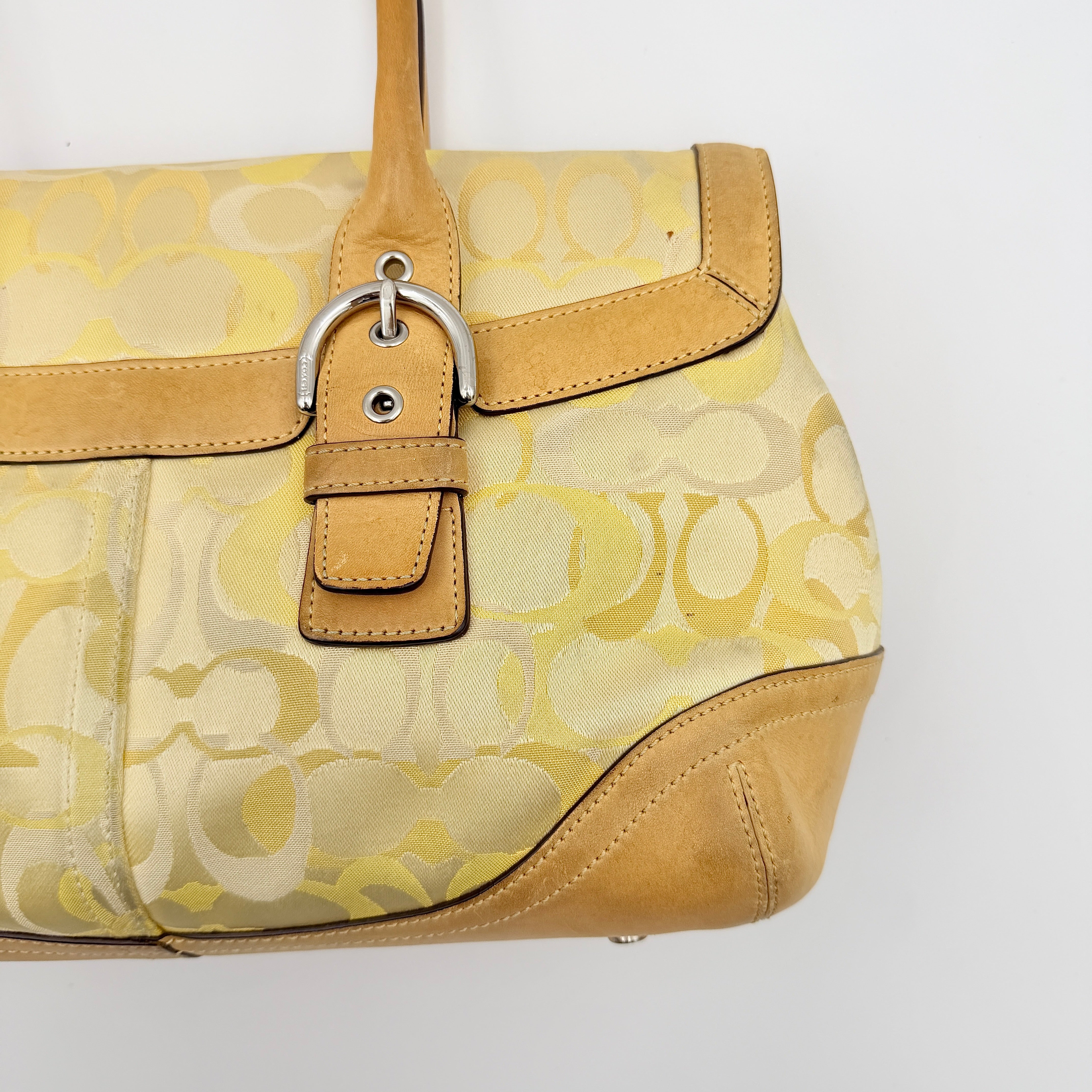 Coach Soho shoulder bag in yellow signature optic fabric with tan leather trim and silver hardware, shown with double handles.
