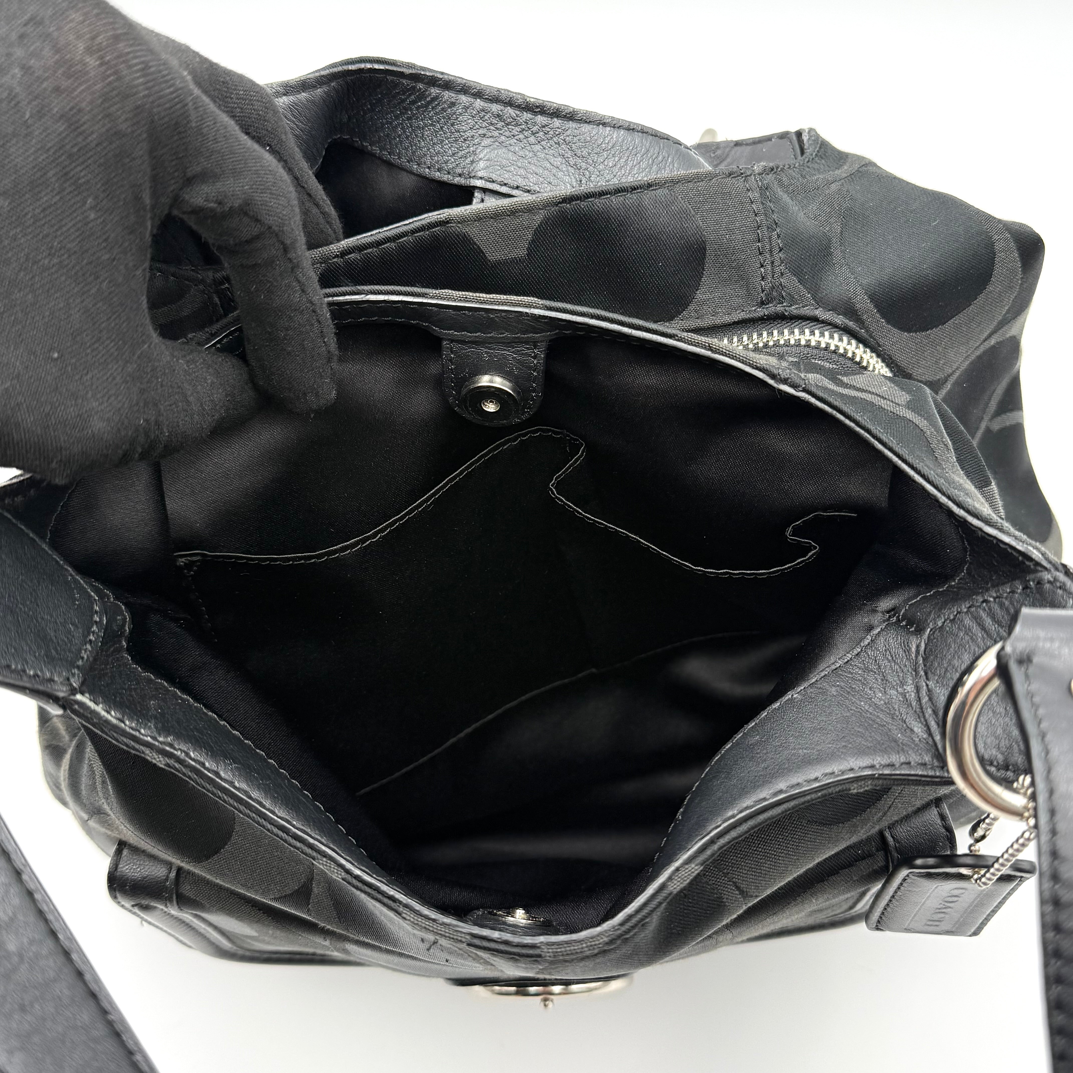 Coach Signature Campbell Hobo Shoulder Bag in black jacquard canvas with leather trim and front buckle pocket, photographed against a white background.