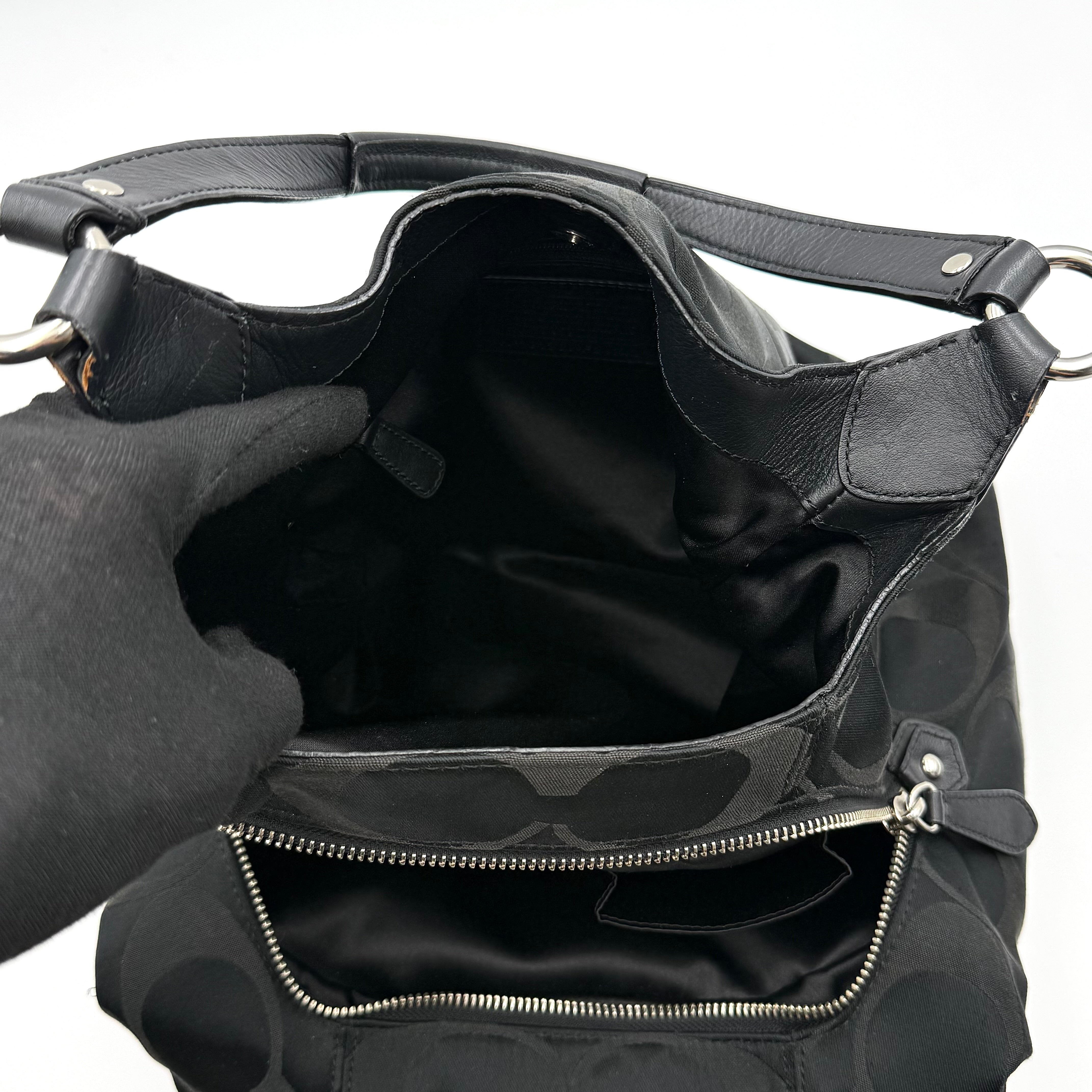 Coach Signature Campbell Hobo Shoulder Bag in black jacquard canvas with leather trim and front buckle pocket, photographed against a white background.