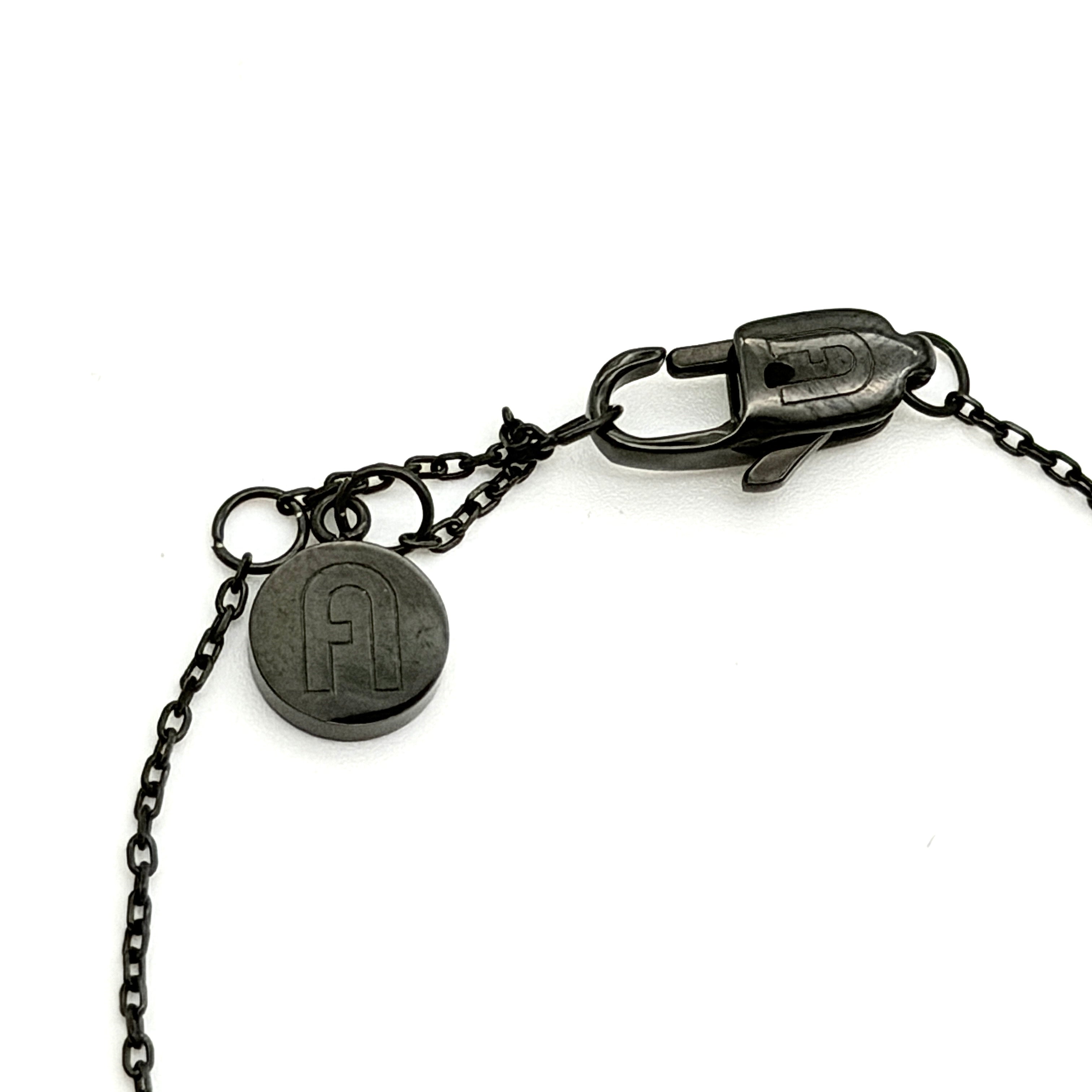 Furla Sigillo black crystal bracelet displayed on branded pouch with authenticity card