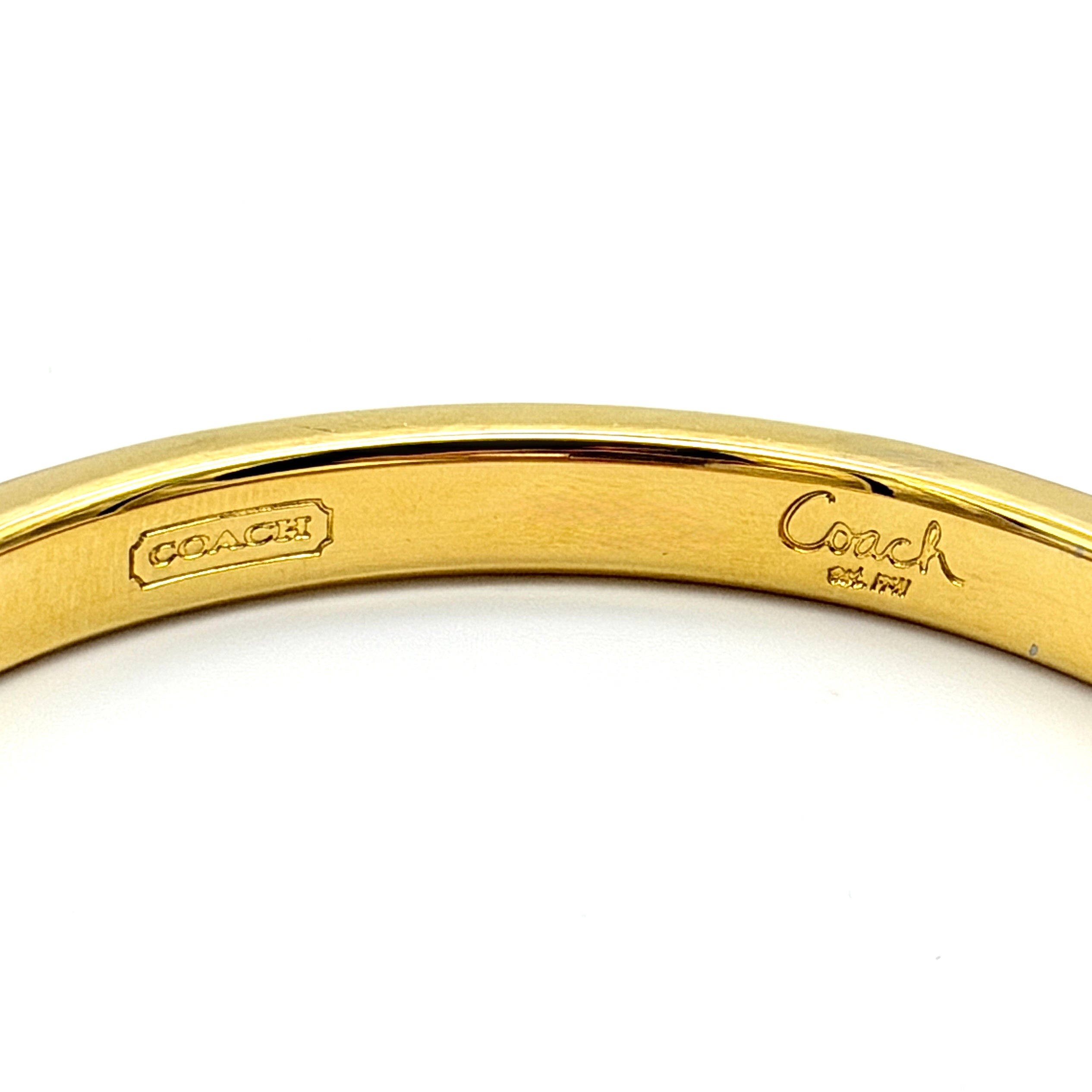 Coach gold studded bangle bracelet with textured finish and rounded gold studs, photographed against a clean background.