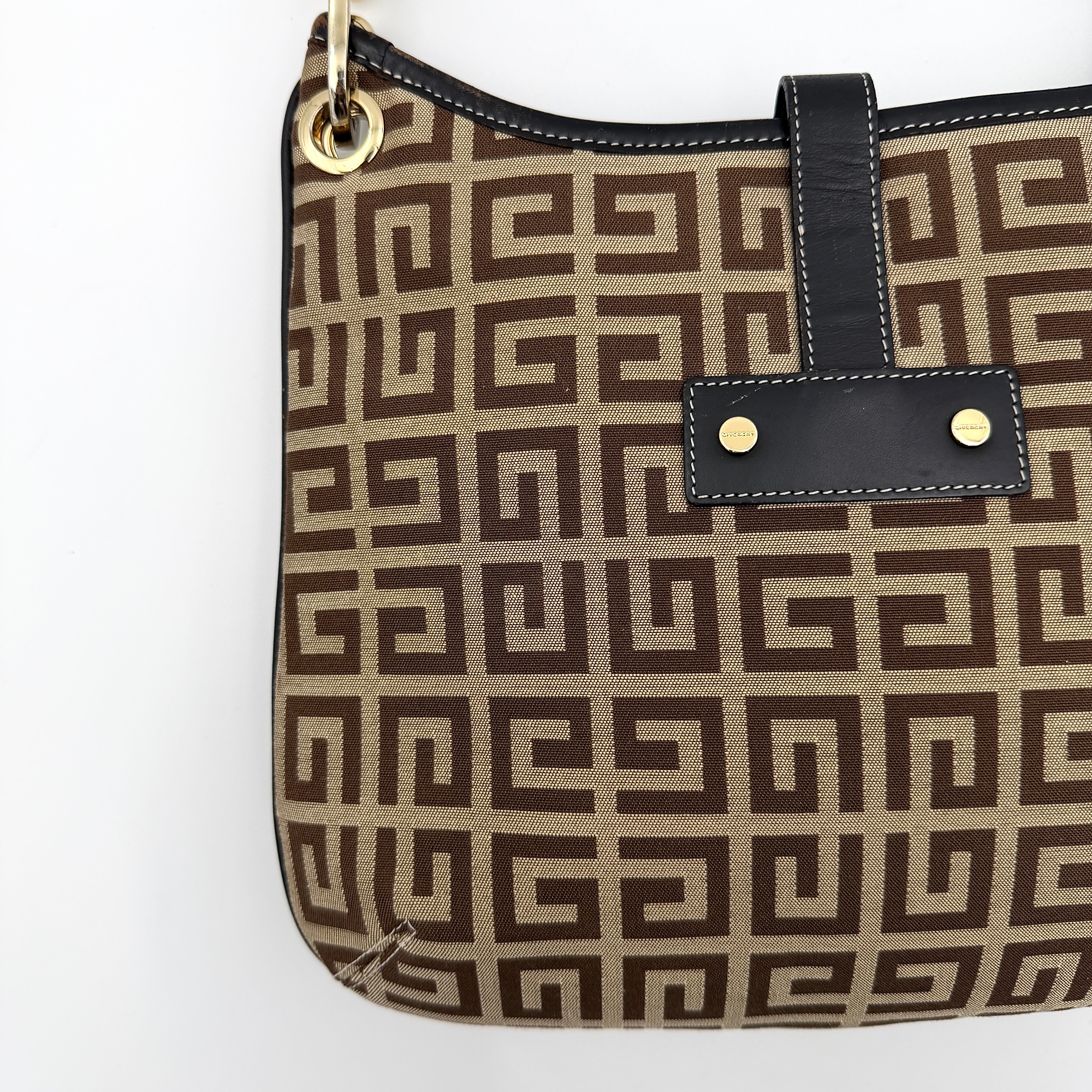 The Givenchy Monogram Hobo Shoulder Bag in brown canvas with black leather trim and gold hardware, displayed front-facing.