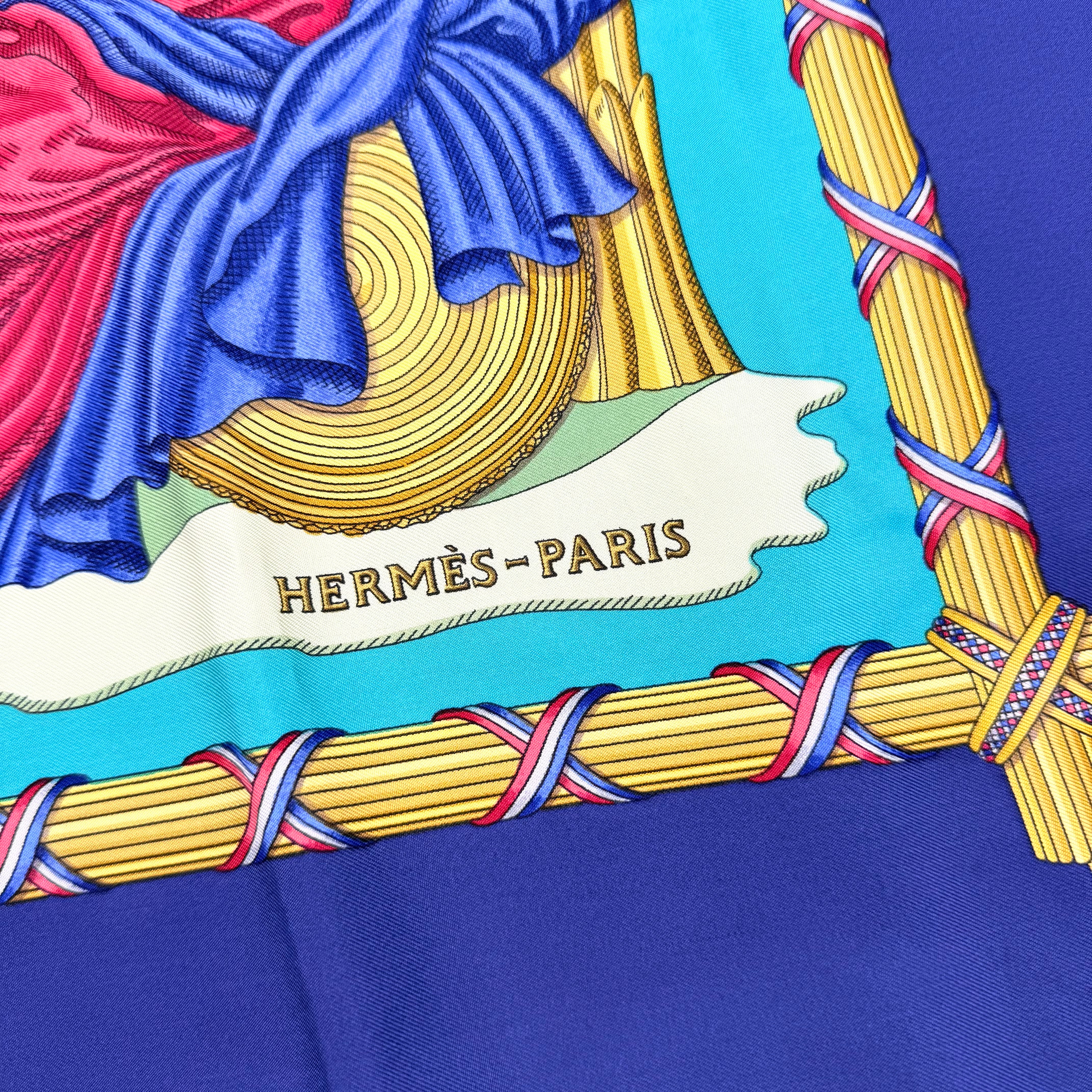Hermès Liberté Égalité Fraternité silk scarf in vibrant blue with classical French motifs and tricolour accents.
