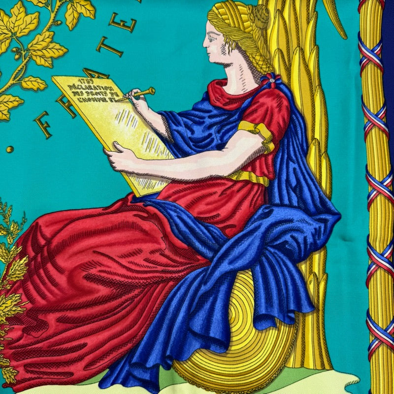 Hermès Liberté Égalité Fraternité silk scarf in vibrant blue with classical French motifs and tricolour accents.
