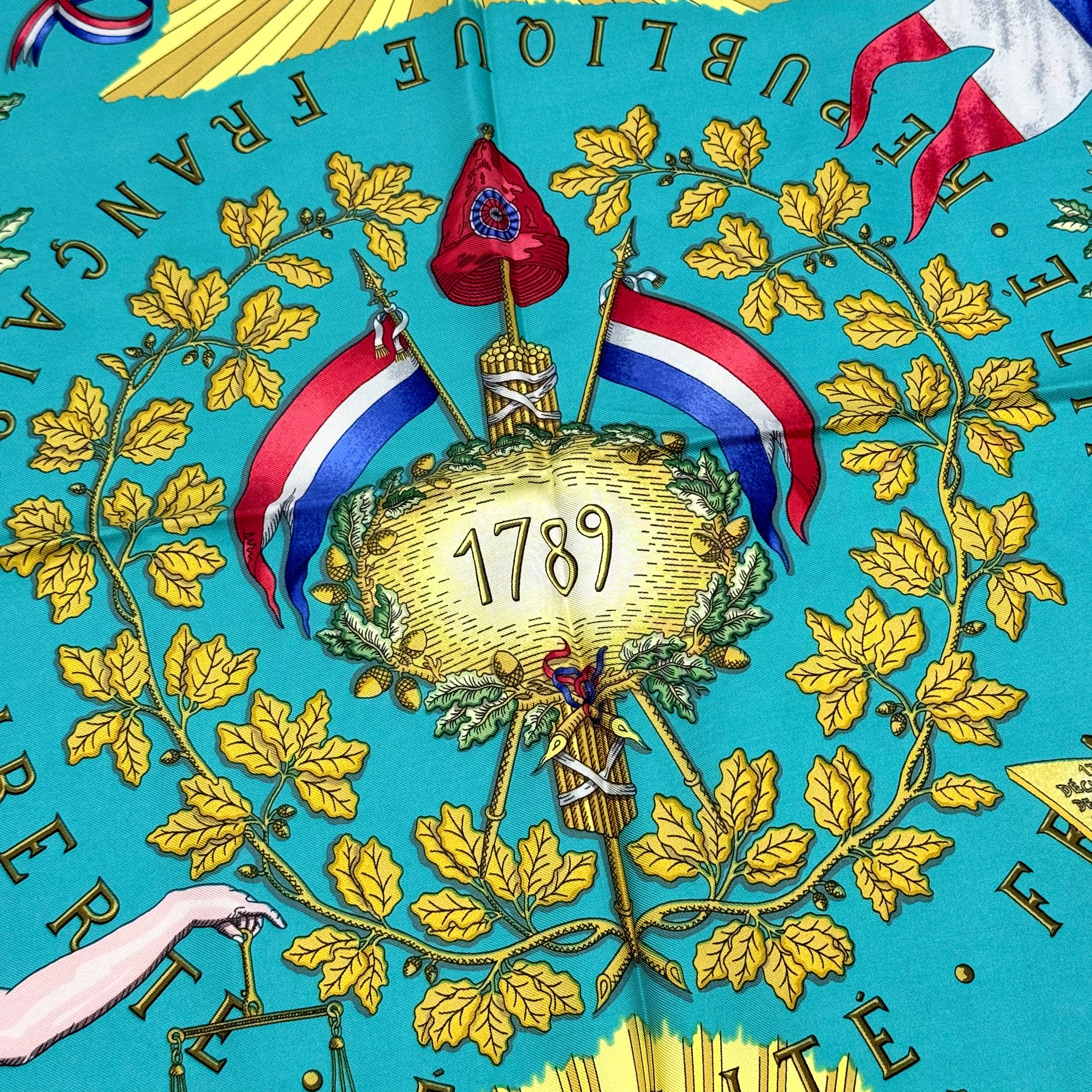 Hermès Liberté Égalité Fraternité silk scarf in vibrant blue with classical French motifs and tricolour accents.