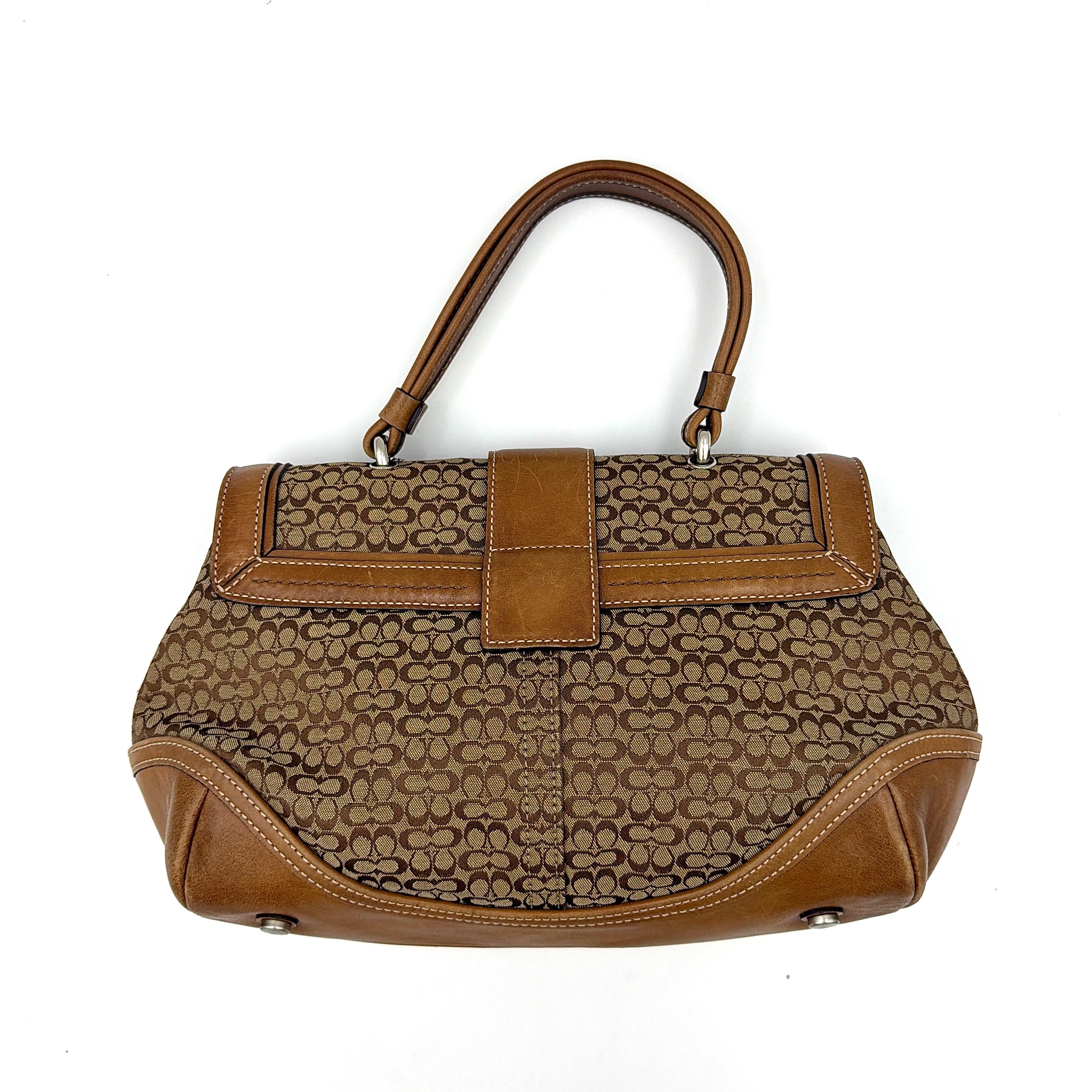Coach Soho Shoulder Bag in beige and tan monogram jacquard with caramel leather trim, featuring silver hardware and a signature buckle flap.
