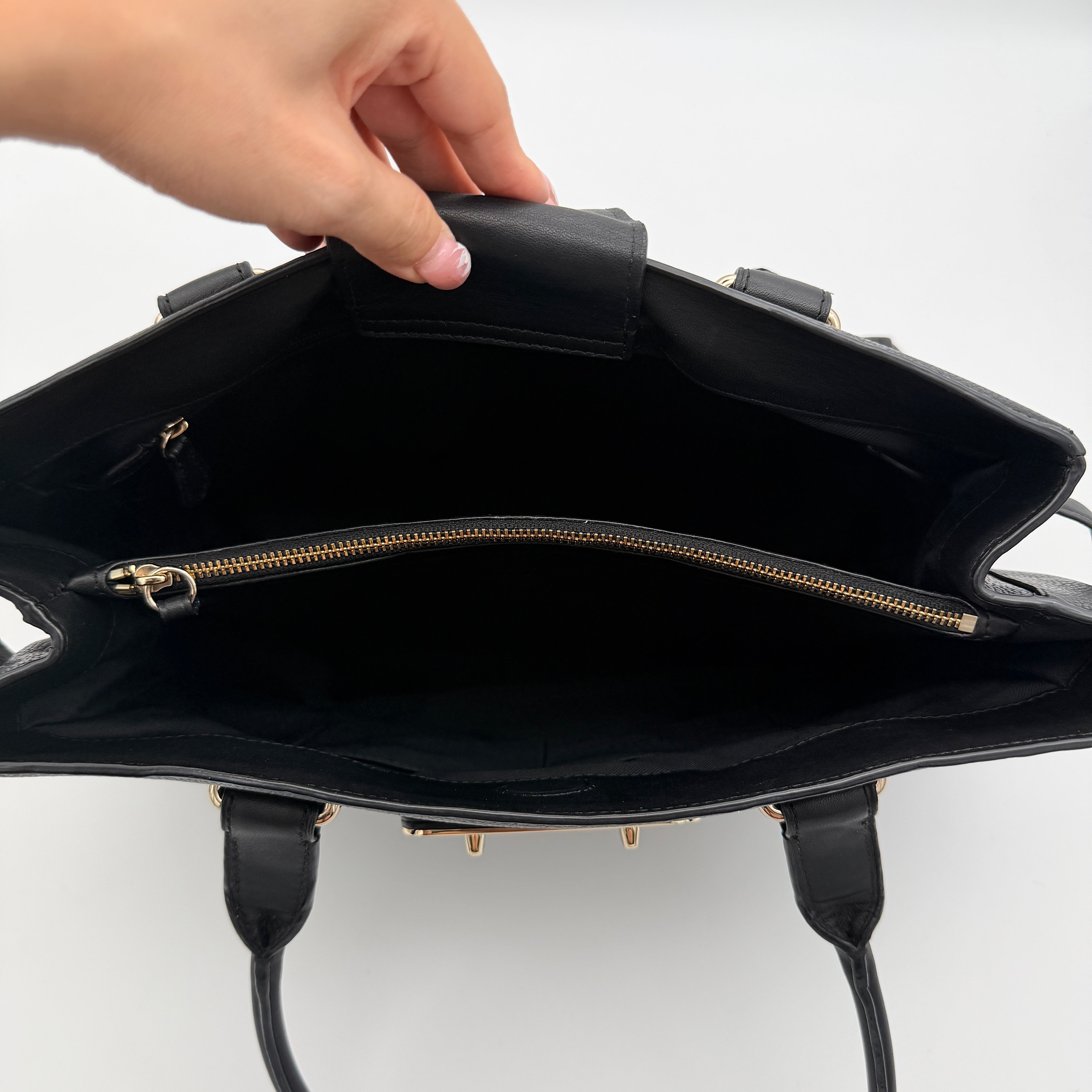 Coach Swagger Carryall in black pebbled leather with gold-tone hardware and double turnlock detail, shown from the front.