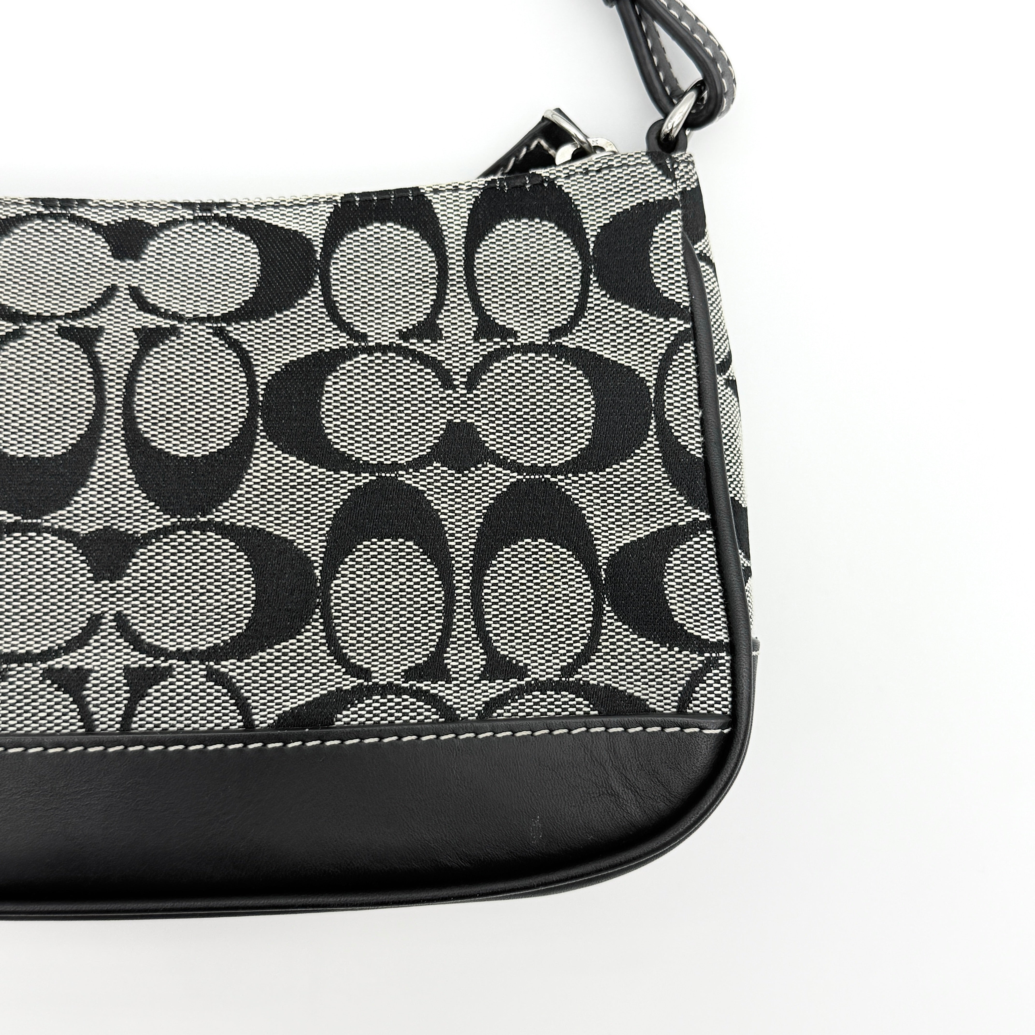 Coach Y2K demi shoulder bag in grey and black signature jacquard with black leather trim and silver hardware, shown with top handle and branded tag.