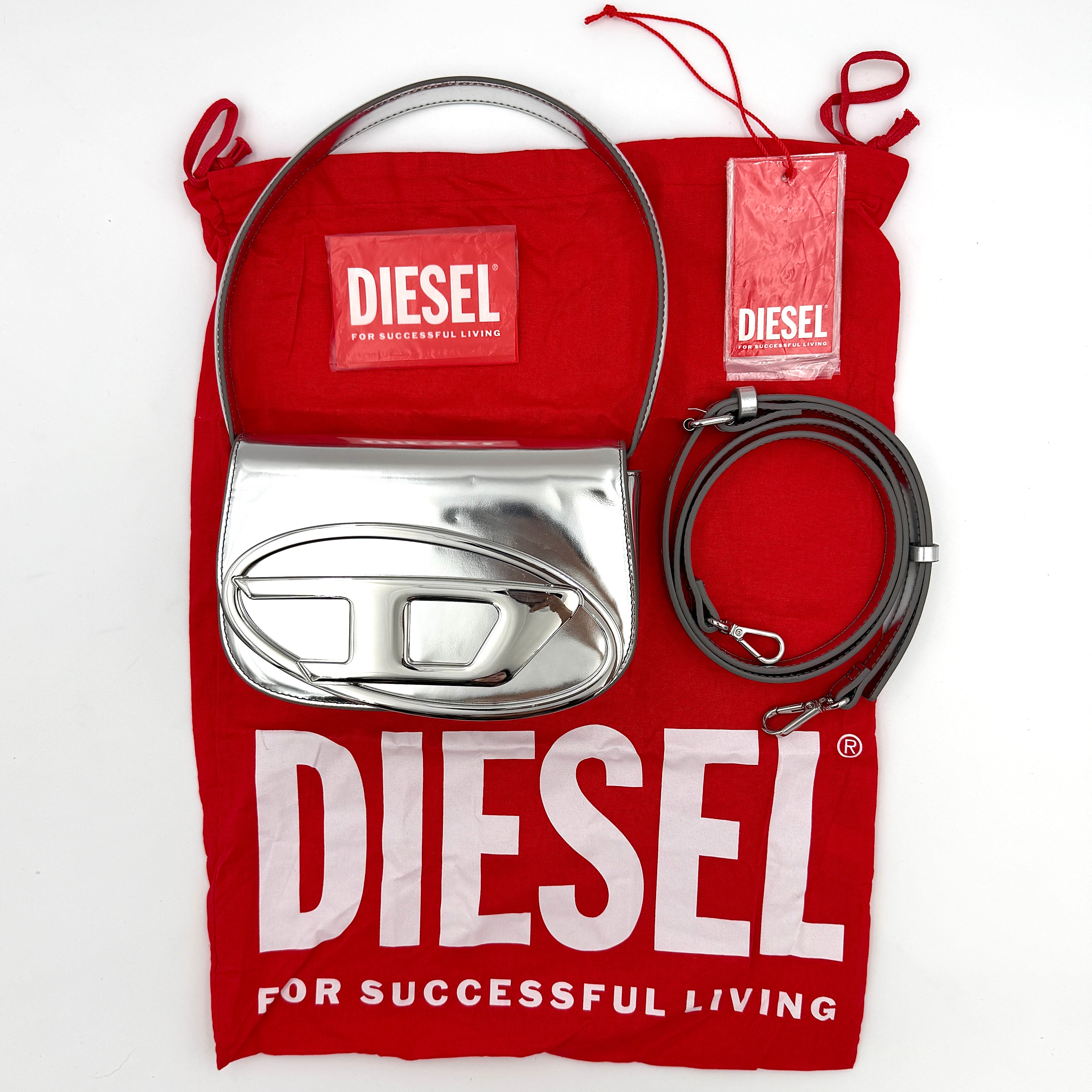 Diesel 1DR 2Way metallic silver shoulder bag with sculptural D logo and detachable strap displayed against a plain background.